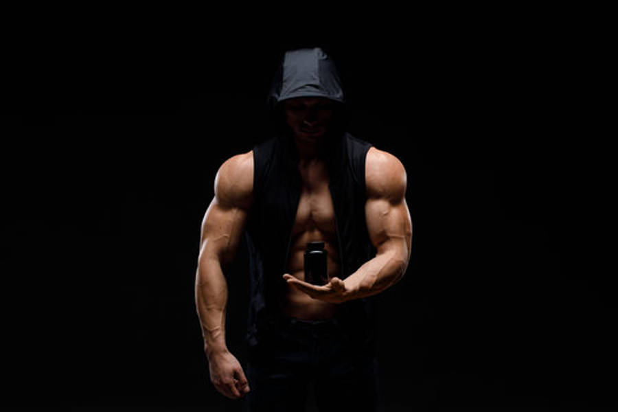 Exercise 桌布 壁紙 — 一個肌肉發達的男人戴著黑色帽子和背心，在漆黑背景下拿著一個罐子。
