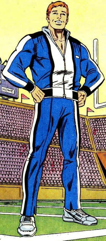 Flash Thompson 桌布 壁紙 — 一個肌肉發達的男人穿著藍白運動服，自信地站在足球場上，身後是體育館座位。