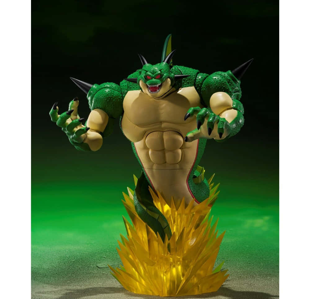 Namek 桌布 壁紙 — 一個肌肉發達的綠色龍形公仔，有尖刺的四肢和發光的紅色眼睛，站在金色火焰底座上，背景是深綠色。