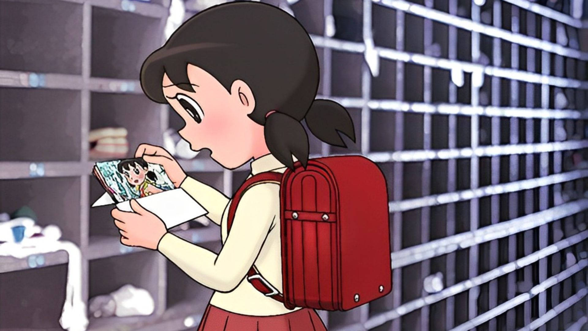 動漫女孩 桌布 壁紙 — 一個背著紅色背包的動漫少女在燈光昏暗的更衣室裡凝視著一本漫畫書。