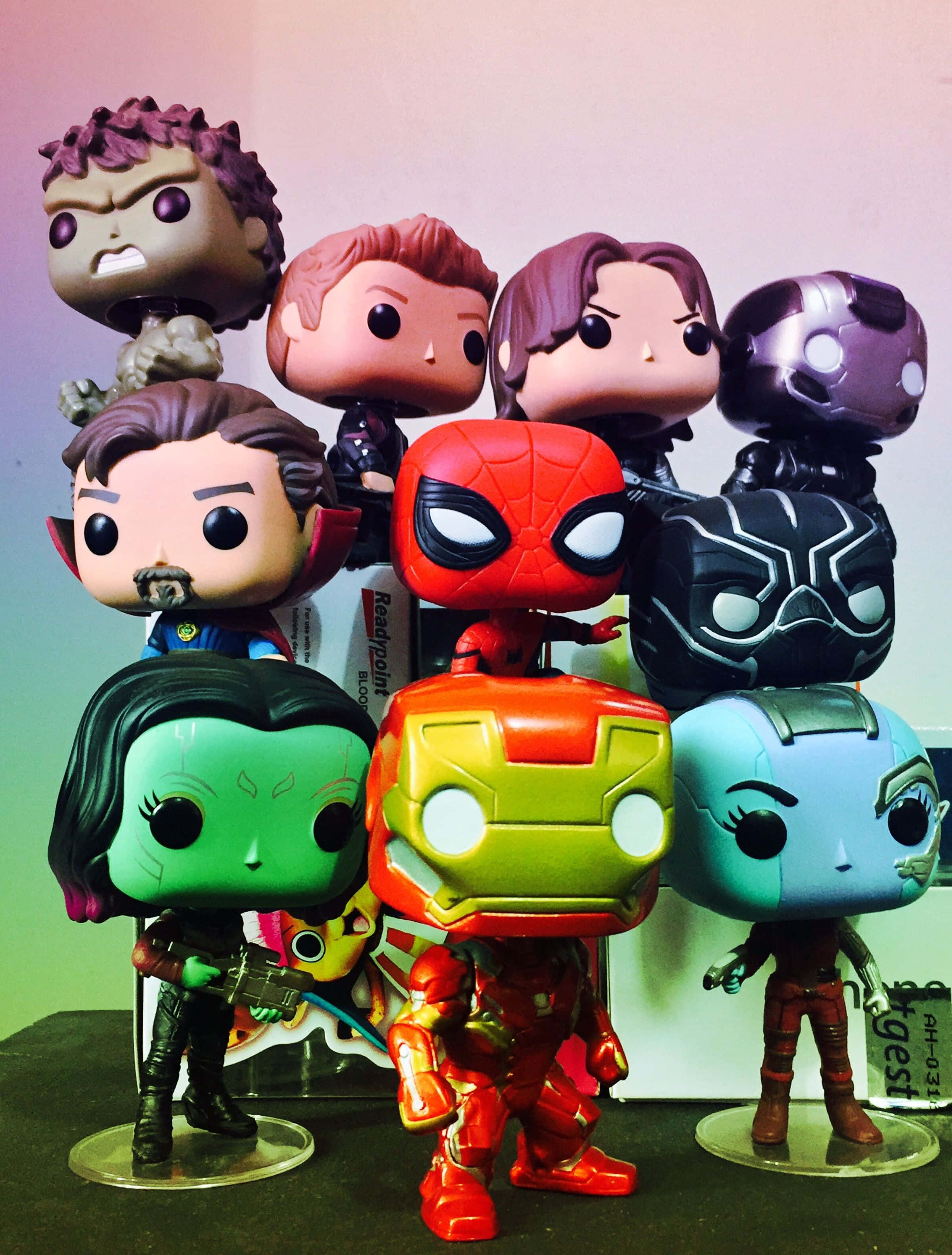 Iron Man Pop Figures 桌布 壁紙 — 一個色彩繽紛的Funko Pop! Marvel超級英雄和反派角色乙烯基公仔系列，一起擺放在架子上。