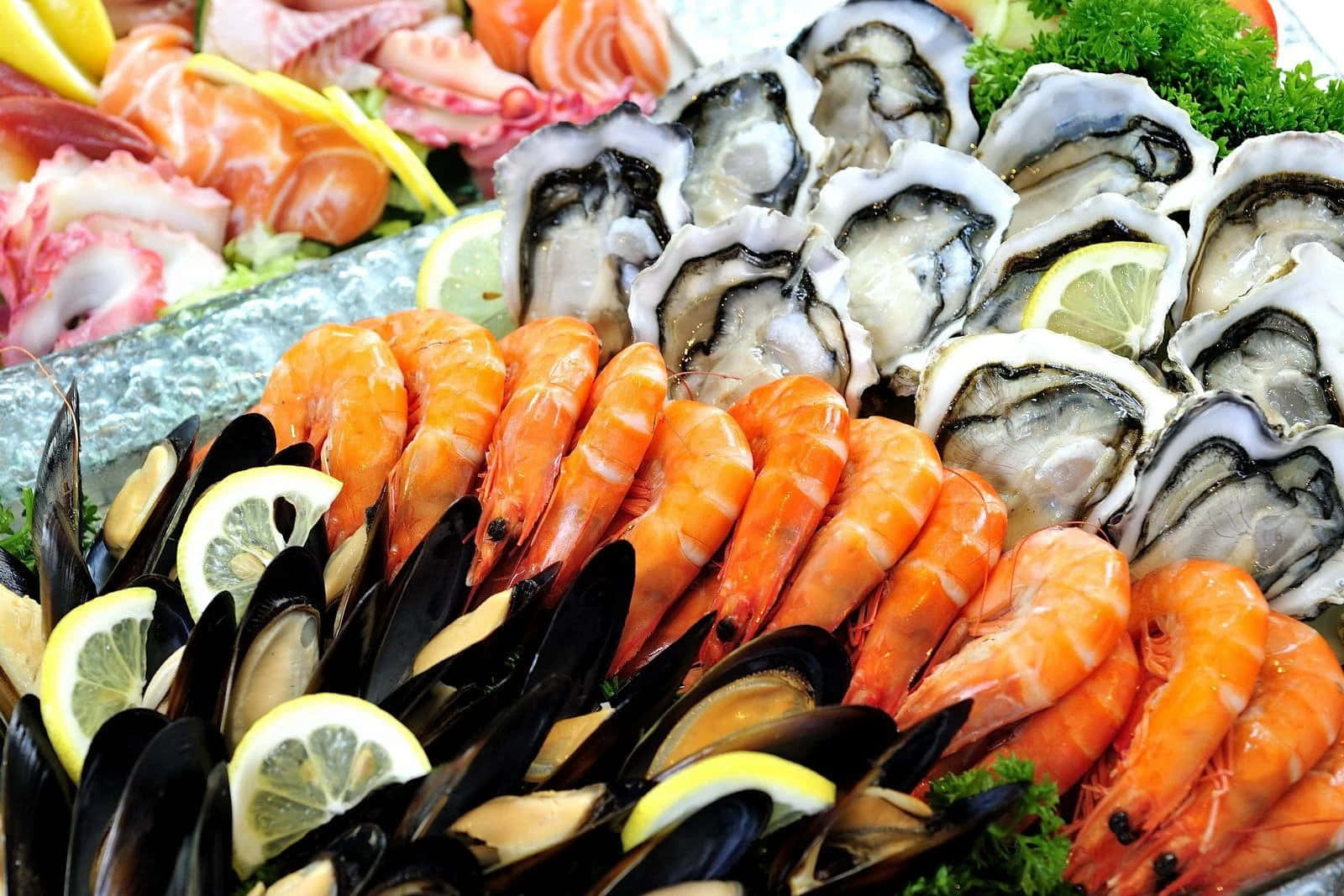 Seafood 桌布 壁紙 — 一個色彩繽紛的海鮮拼盤展示了新鮮的牡蠣、蝦、青口和刺身，並以檸檬片和歐芹裝飾。