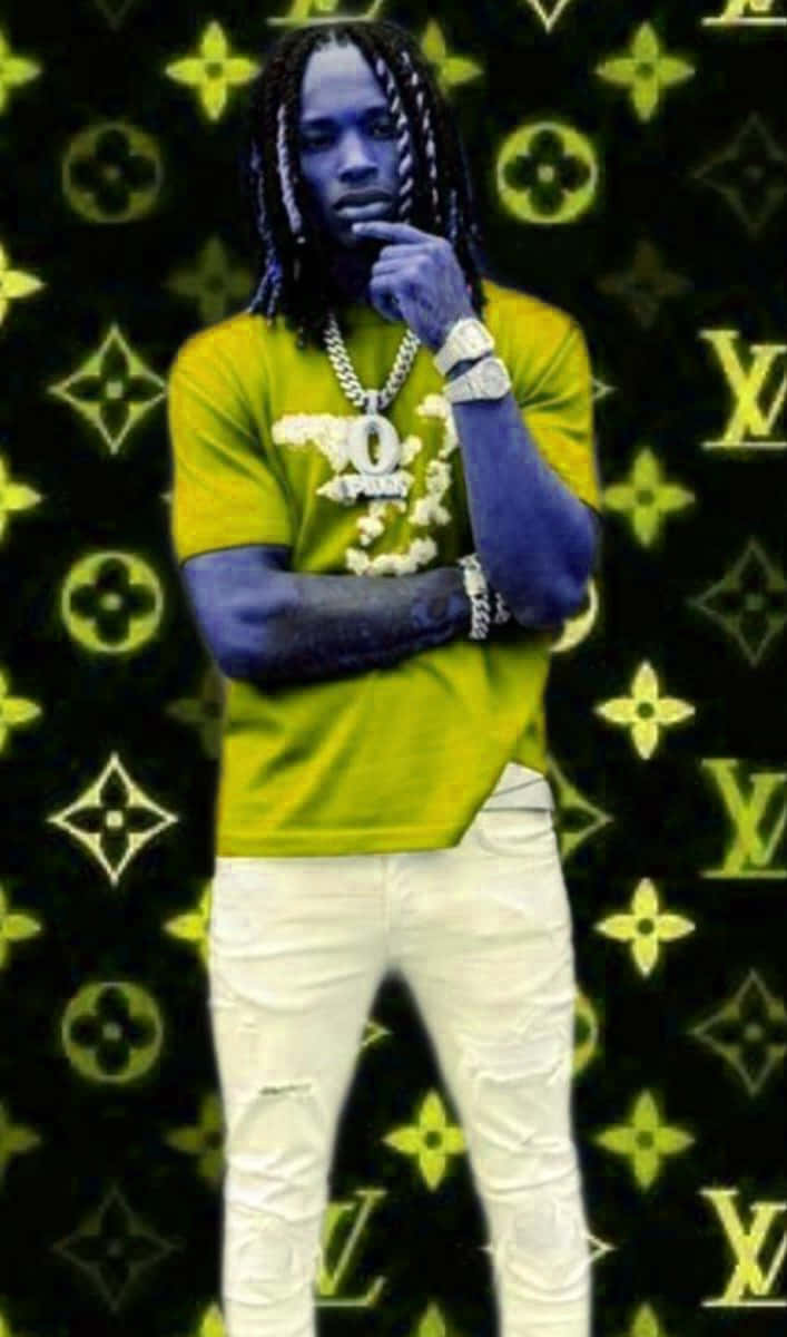 King Von 桌布 壁紙 — 一個藍皮膚和辮子頭的男人在發光的黃色 Louis Vuitton 圖案背景前沉思地擺姿勢。