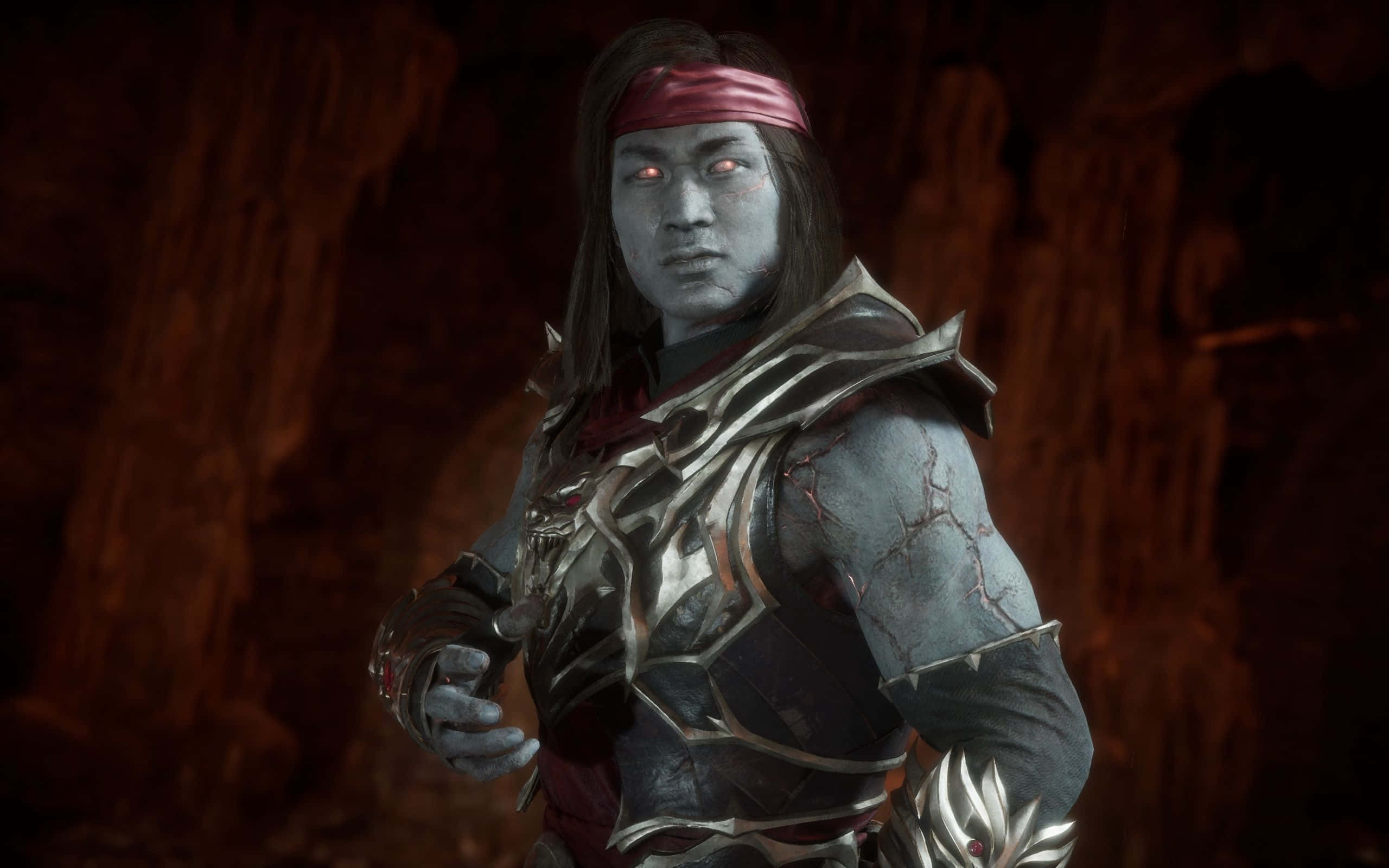 Mortal Kombat Liu Kang 桌布 壁紙 — 一個藍皮膚的戰士，擁有發光的紅色眼睛和華麗的盔甲，站在昏暗的洞穴中，散發出強烈的力量。