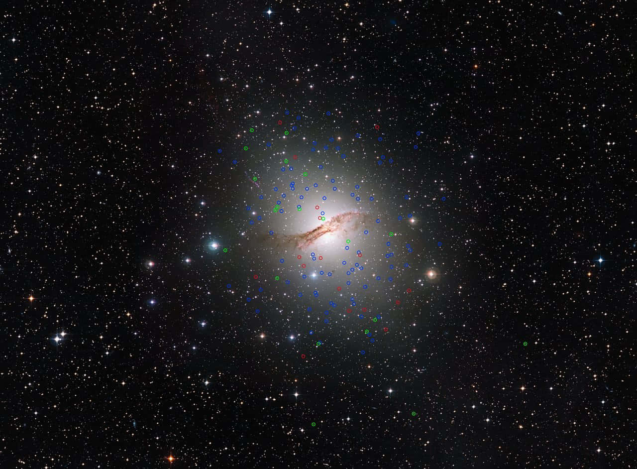 Elliptical Galaxy 桌布 壁紙 — 一個螺旋星系，散發著白色和橙色的色調，被無數恆星和彩色數據標記包圍，背景是黑色的宇宙。