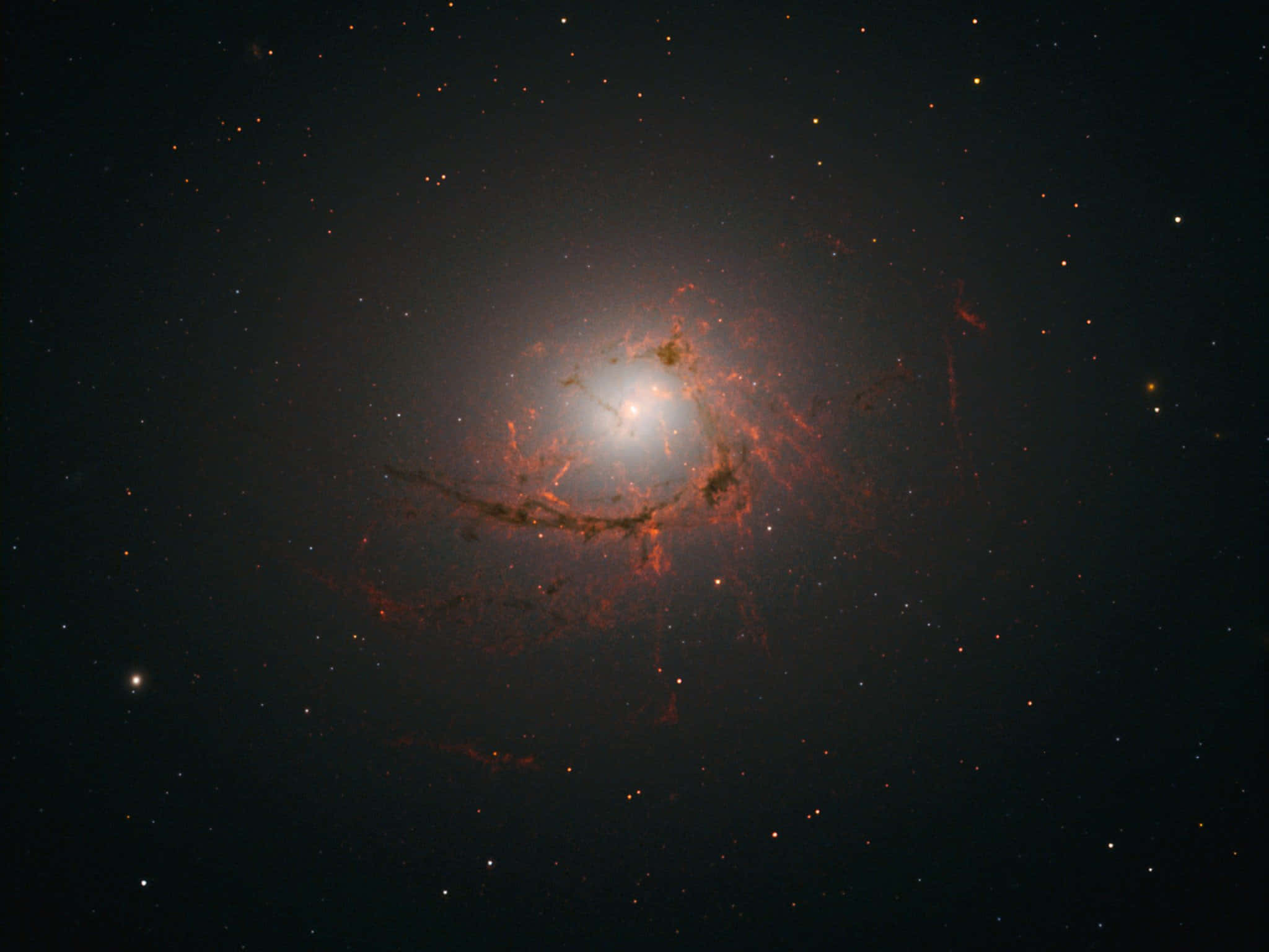 Elliptical Galaxy 桌布 壁紙 — 一個螺旋星系在深空星場中發出熾熱的橙色旋臂光芒。