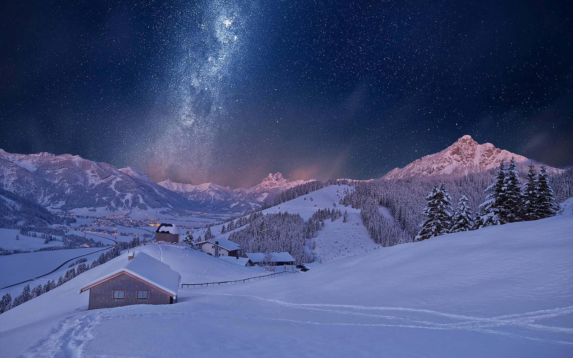 冬天桌面 桌布 壁紙 — 一個被雪覆蓋的山村，在充滿活力的星空下，銀河拱橋般橫跨天際。