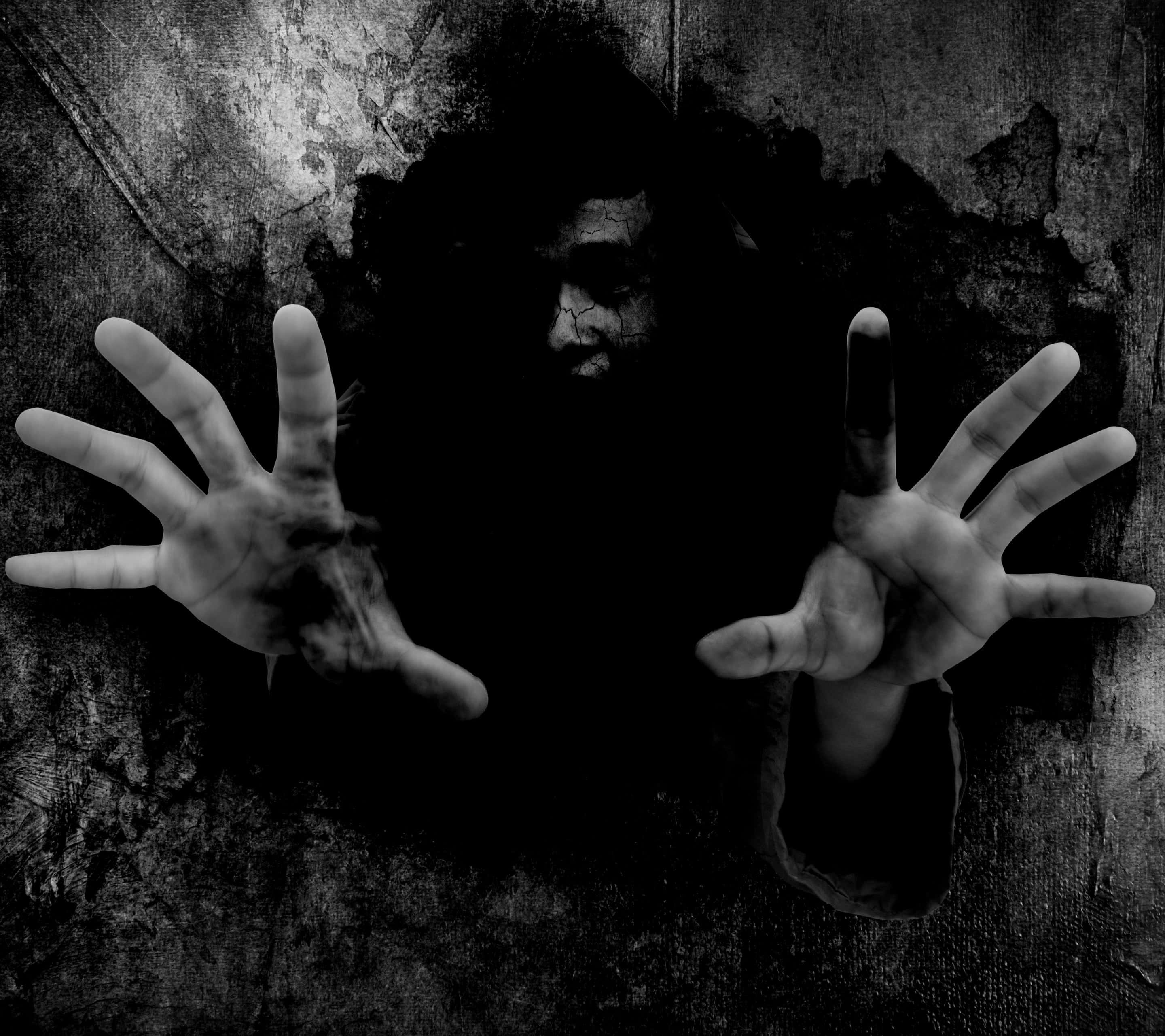 Dark Fear 桌布 壁紙 — 一個裂面伸手的鬼影從風化牆壁的暗洞中浮現，以單色呈現。