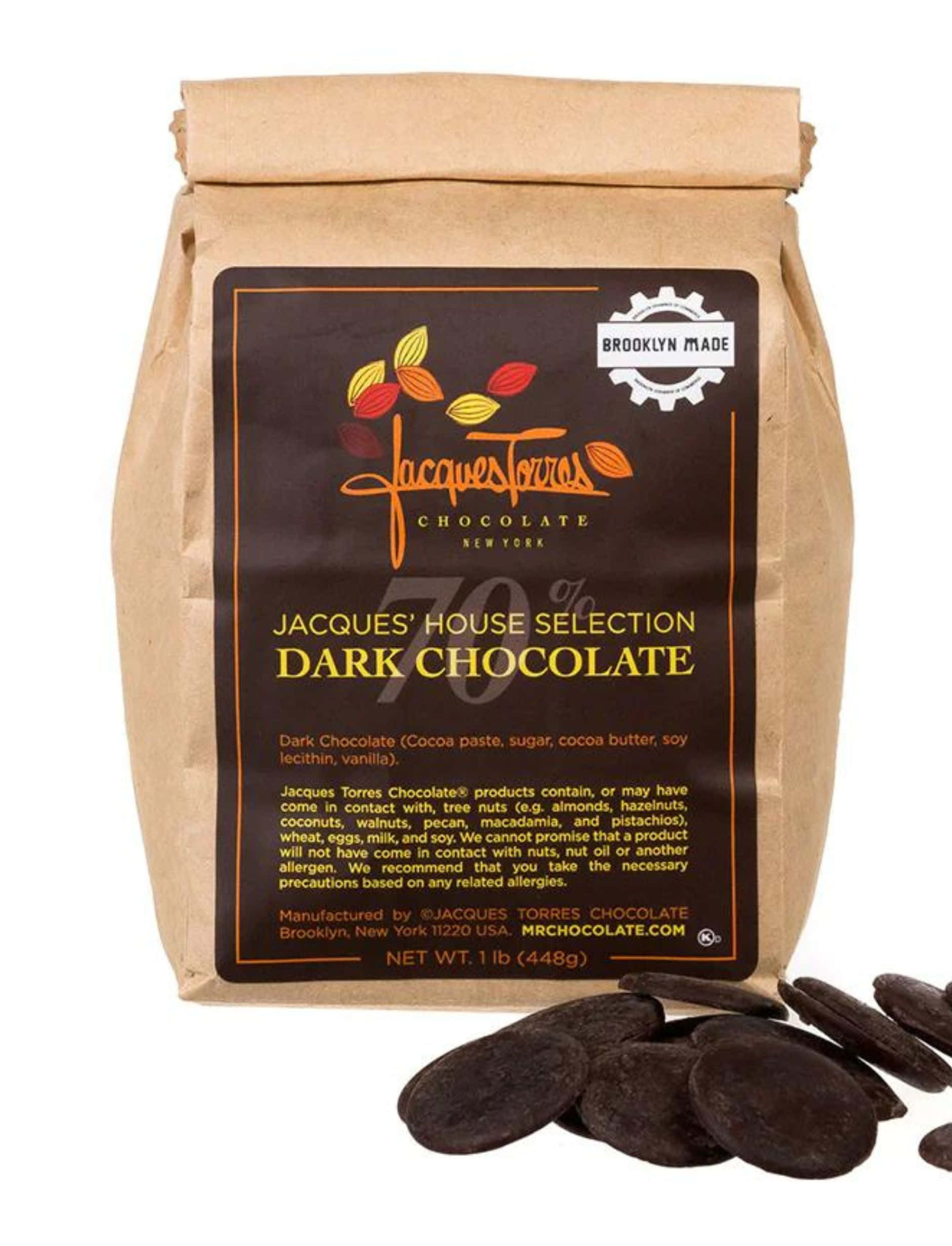 Dark Chocolate 桌布 壁紙 — 一個裝有Jacques Torres 70%黑朱古力的棕色紙袋，白色背景上散落著朱古力圓片。