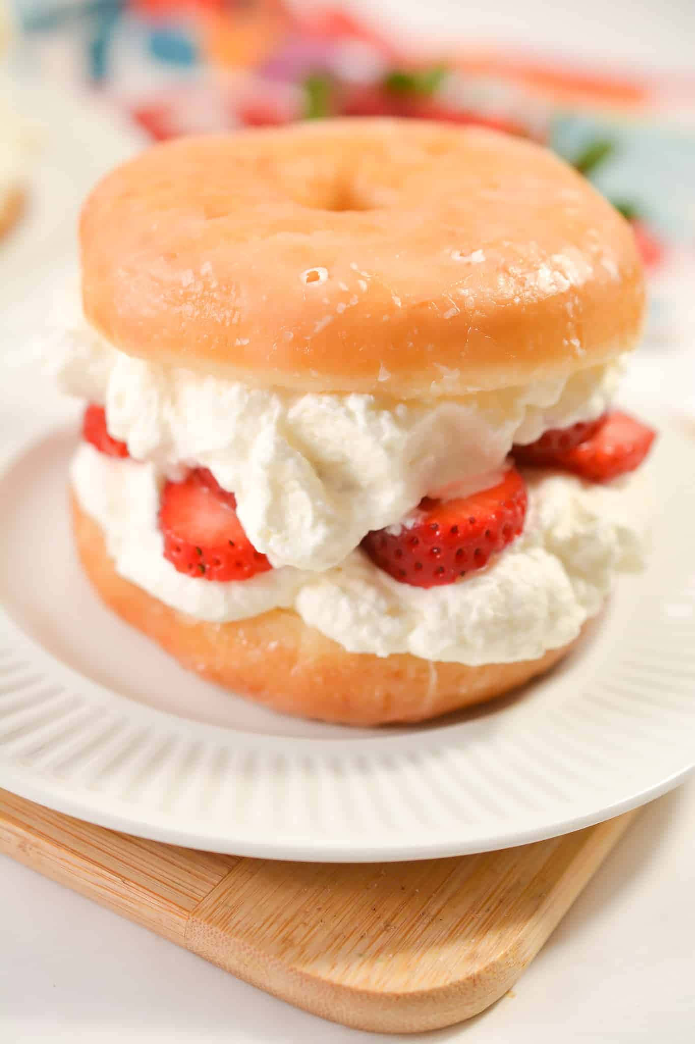 Glazed Donut 桌布 壁紙 — 一個裝滿忌廉和新鮮草莓的糖霜冬甩三文治放在木板上嘅白色碟上。
