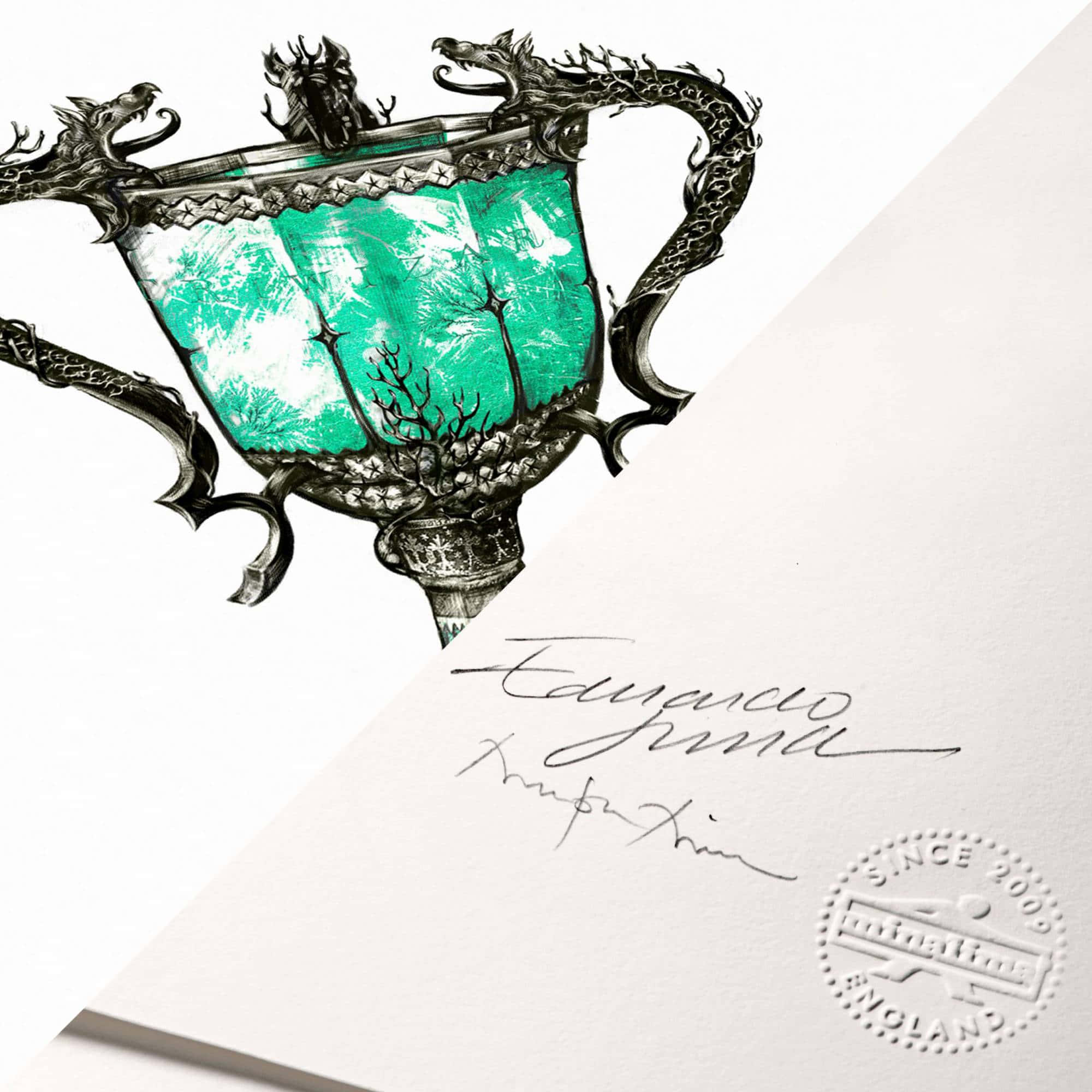 The Triwizard Cup 桌布 壁紙 — 一個裝飾華麗的銀獎盃，帶有龍形手柄，其碗部包含一個充滿活力的藍綠色森林場景。