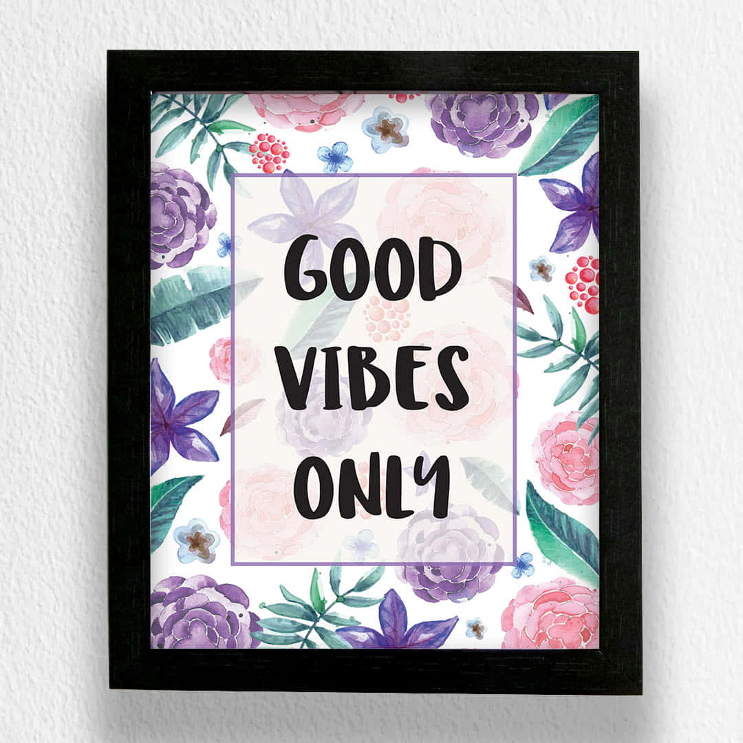Vibes 桌布 壁紙 — 一個裱框的水彩花卉海報，上面有「GOOD VIBES ONLY」文字，周圍環繞著粉紅色、紫色和綠色的花朵，掛在白色牆上。