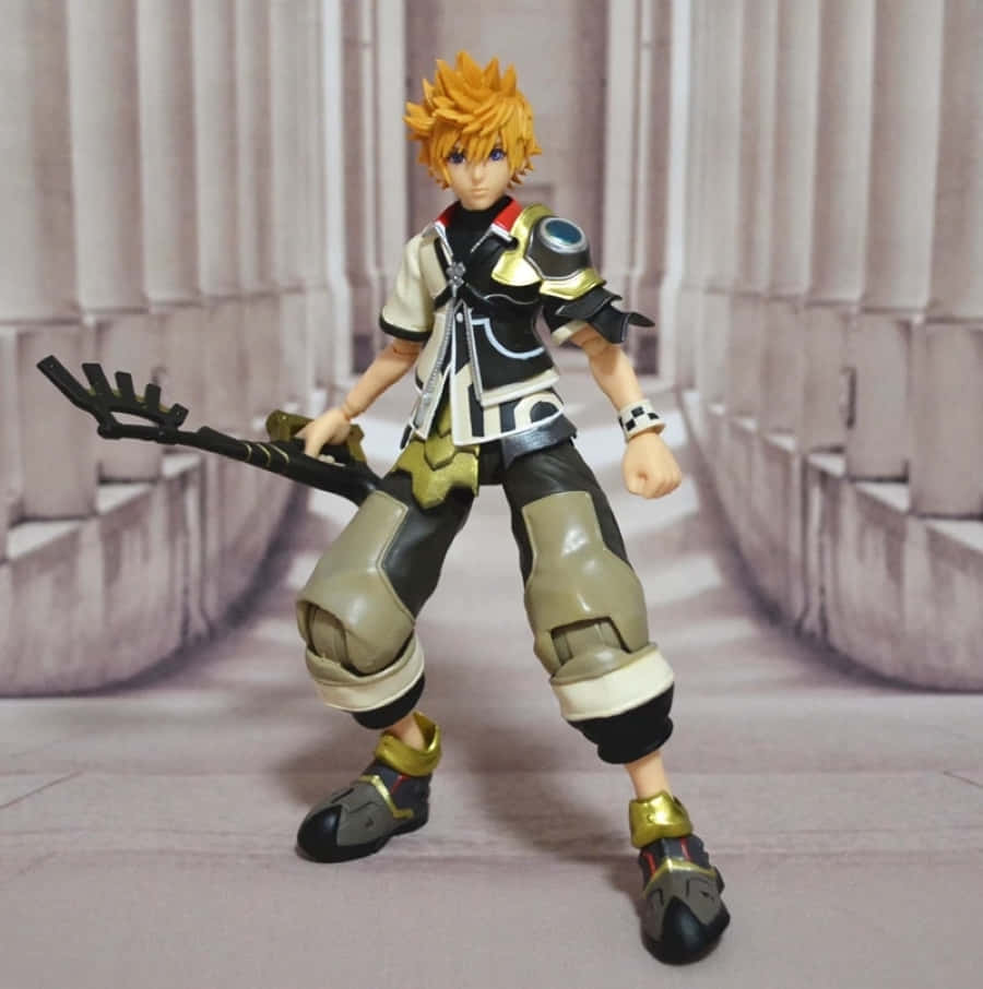 Kingdom Hearts Ventus 桌布 壁紙 — 一個詳細的動作人偶，一個刺蝟頭髮的動漫角色，穿著黑金盔甲，手持鑰刃，站在石頭走廊中。