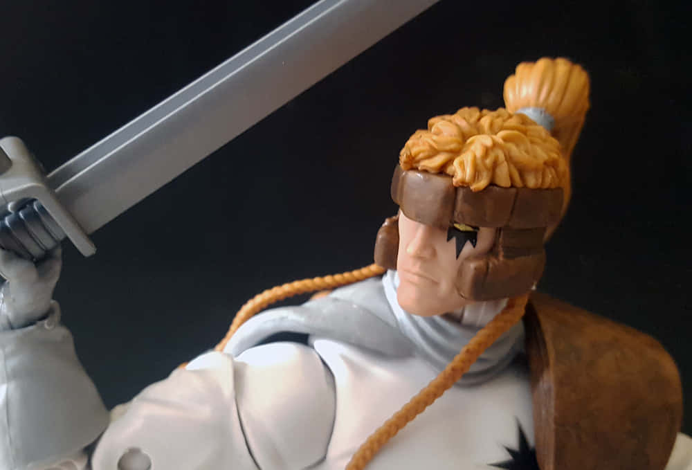 Shatterstar 桌布 壁紙 — 一個詳細的動漫戰士公仔，辮子頭髮，劍舉起，背景黑暗。
