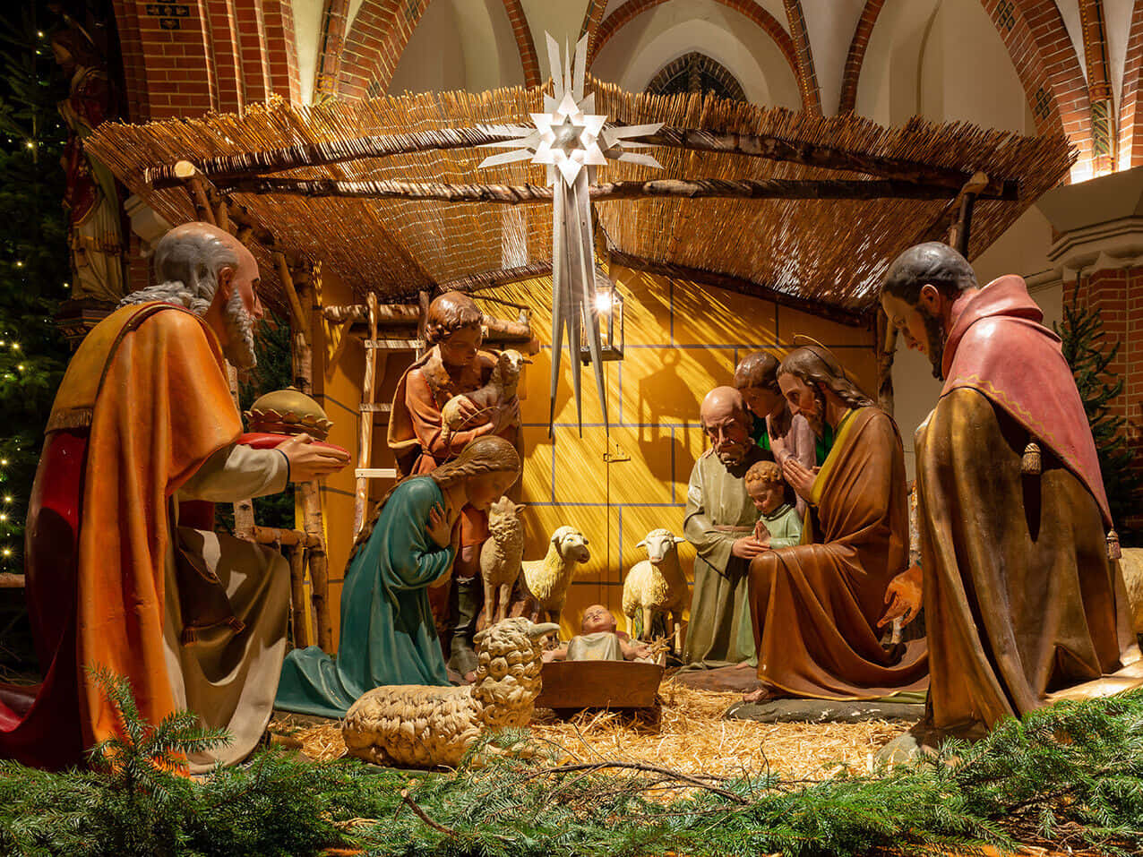 Nativity Scene 桌布 壁紙 — 一個詳細的耶穌誕生場景，有瑪利亞、約瑟和嬰兒耶穌在馬槽中的雕像，周圍有牧羊人和羊，上方有星星。