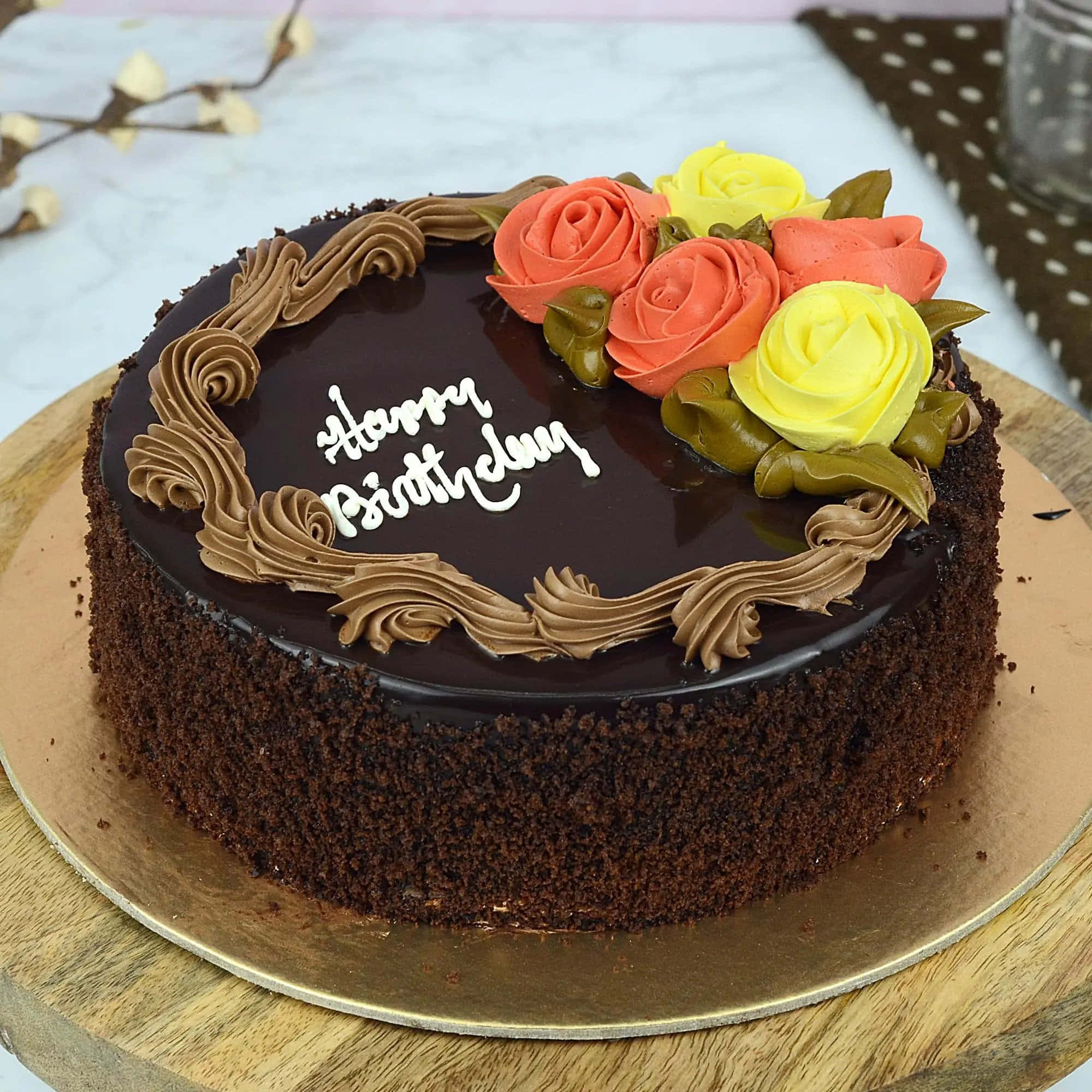 生日蛋糕 桌布 壁紙 — 一個豐富的朱古力生日蛋糕，上面有棕色糖霜漩渦和鮮豔的橙黃色玫瑰，放在木板上。