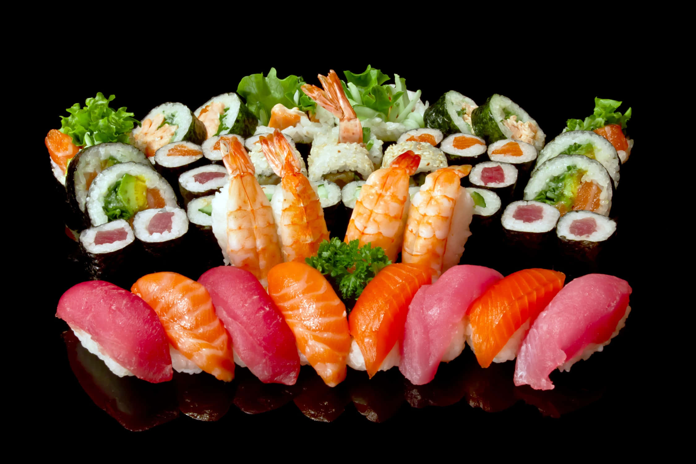 Seafood 桌布 壁紙 — 一個豪華的壽司拼盤，上面有色彩鮮豔的刺身和卷物，擺放在光亮的黑色表面上，配以新鮮裝飾。