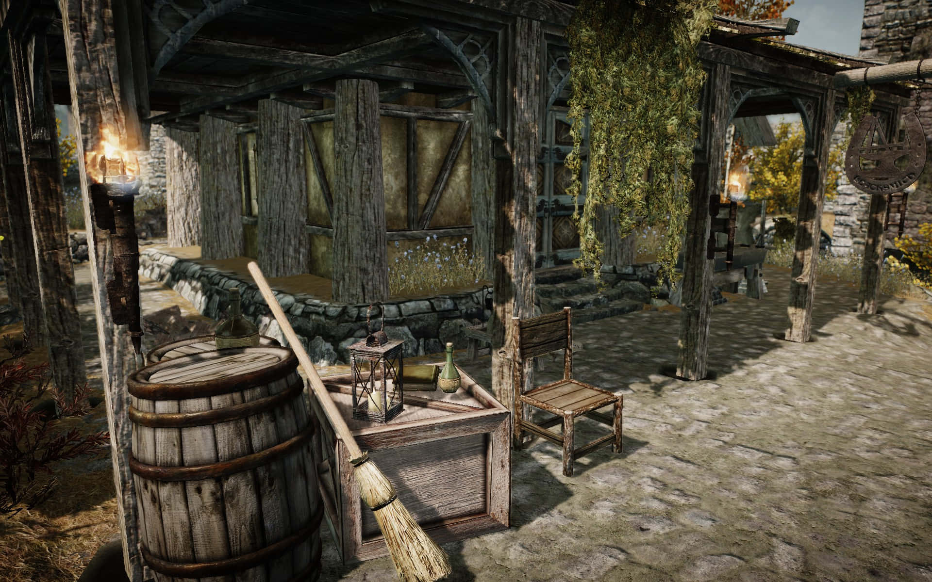 Skyrim Whiterun 桌布 壁紙 — 一個質樸的中世紀庭院，有木桶、掃帚和石徑，沐浴在溫暖的金色陽光中。