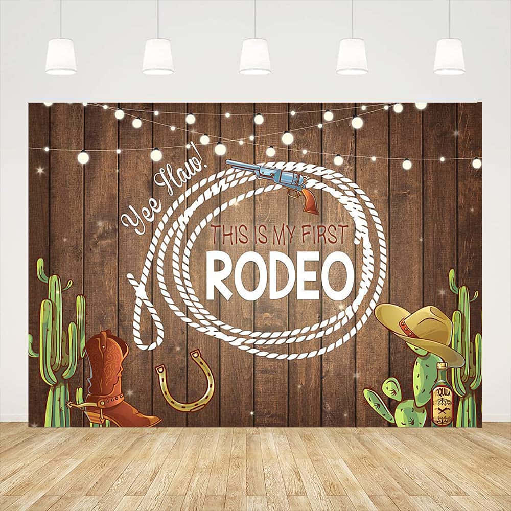 Rodeo 桌布 壁紙 — 一個質樸的木製背景，配有燈串、牛仔靴、仙人掌和一條拼出「This Is My First Rodeo」的繩索，用於西部主題攝影。