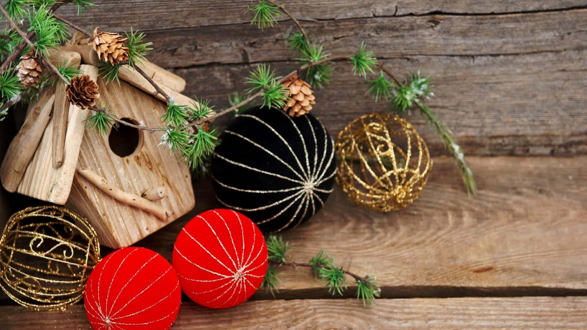 Rustic Christmas 桌布 壁紙 — 一個質樸的木製鳥屋和節日裝飾品放在風化的木頭上，點綴著松樹枝和松果。