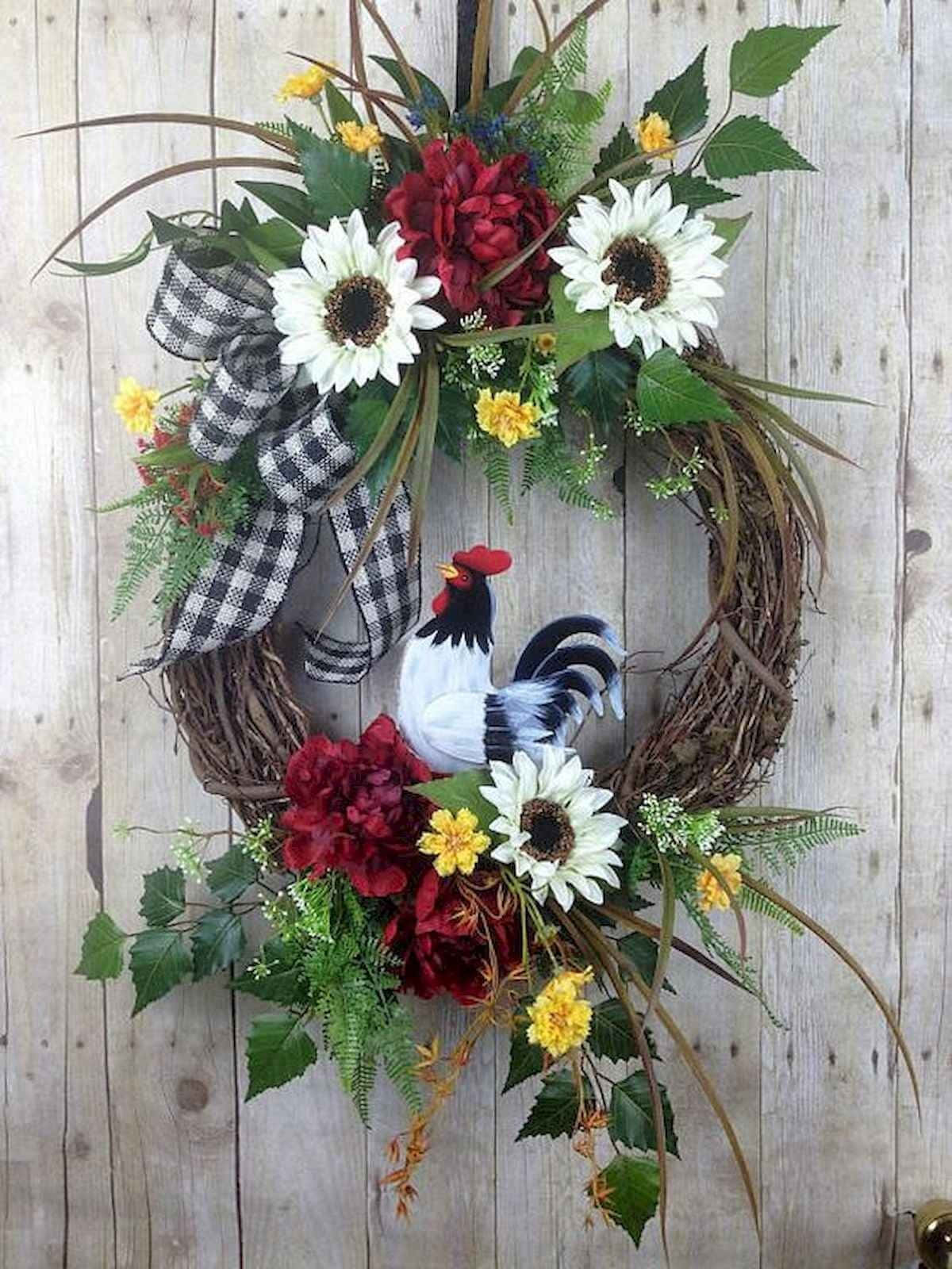 Spring Wreaths 桌布 壁紙 — 一個質樸的花環，裝飾著向日葵、紅色花朵、綠色蕨類植物和格子蝴蝶結，掛在風化的木質壁板上。