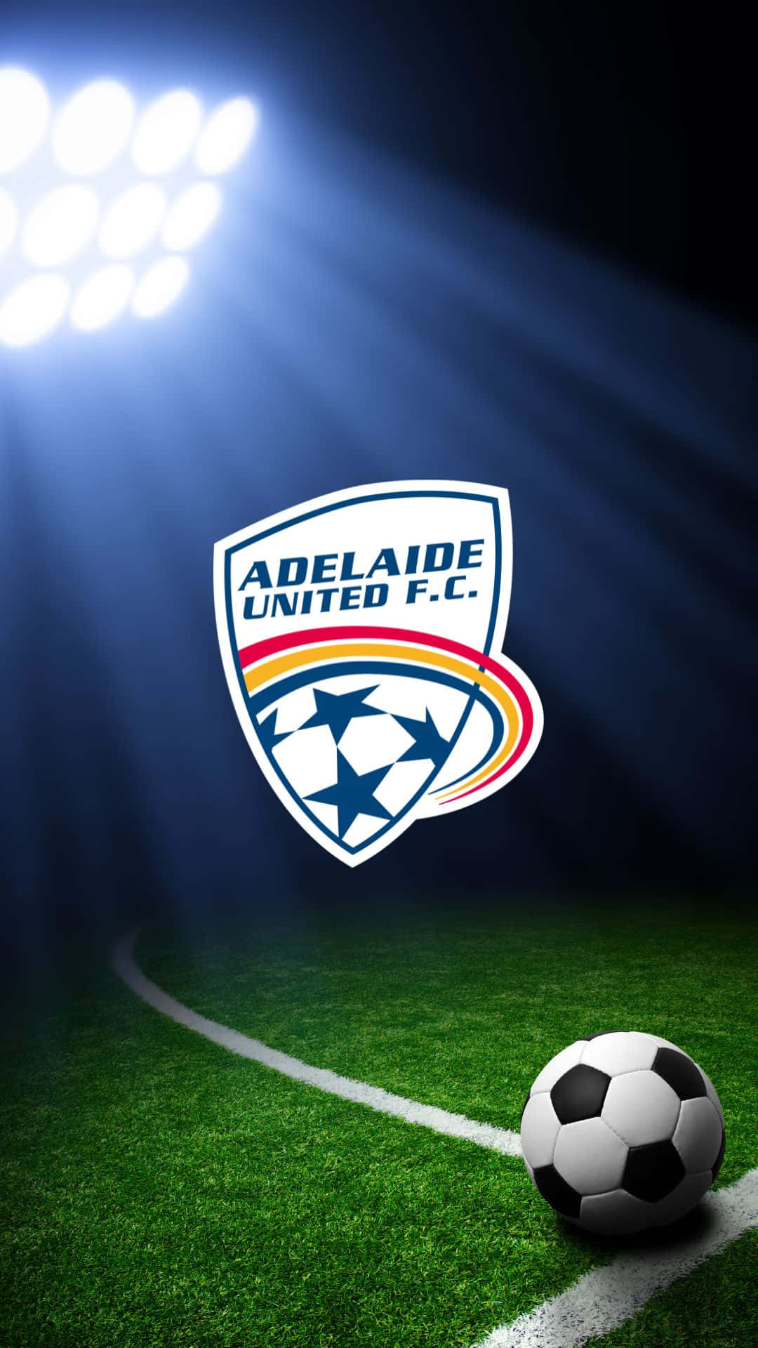 Adelaide United 桌布 壁紙 — 一個足球放在充滿活力的綠色球場上，在明亮的球場燈光下，中央閃耀著阿德萊德聯足球會的標誌。