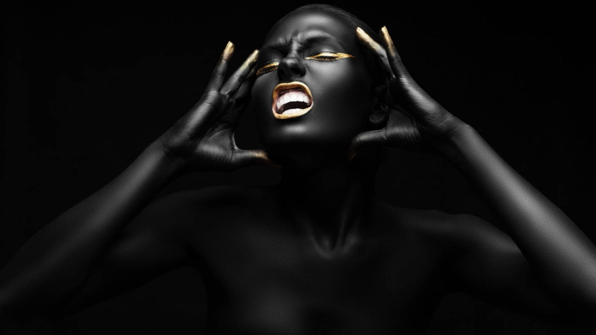 Black Woman 桌布 壁紙 — 一個身上塗有黑色顏料和金色點綴的人，在黑暗背景下戲劇性地尖叫。