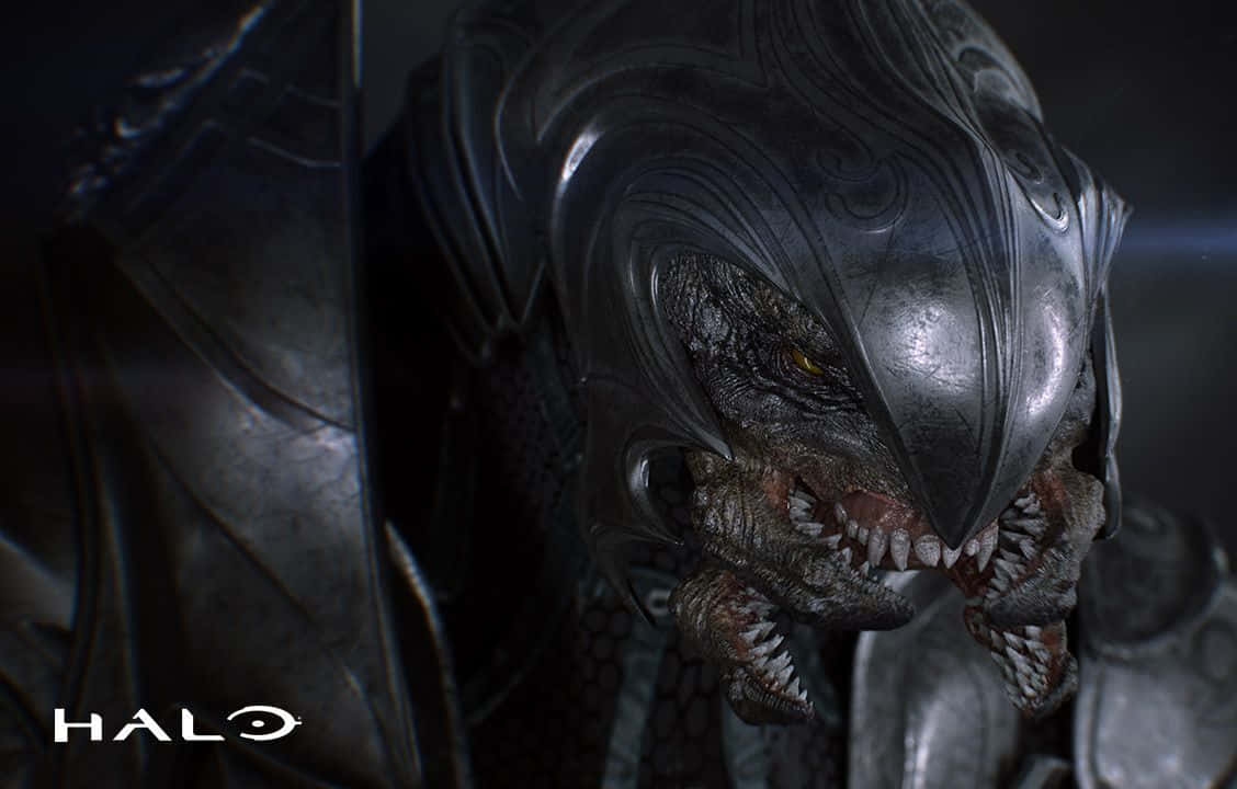 Halo Arbiter 桌布 壁紙 — 一個身穿暗色盔甲、擁有發光黃色眼睛和尖銳牙齒的Halo外星人的威脅性特寫。
