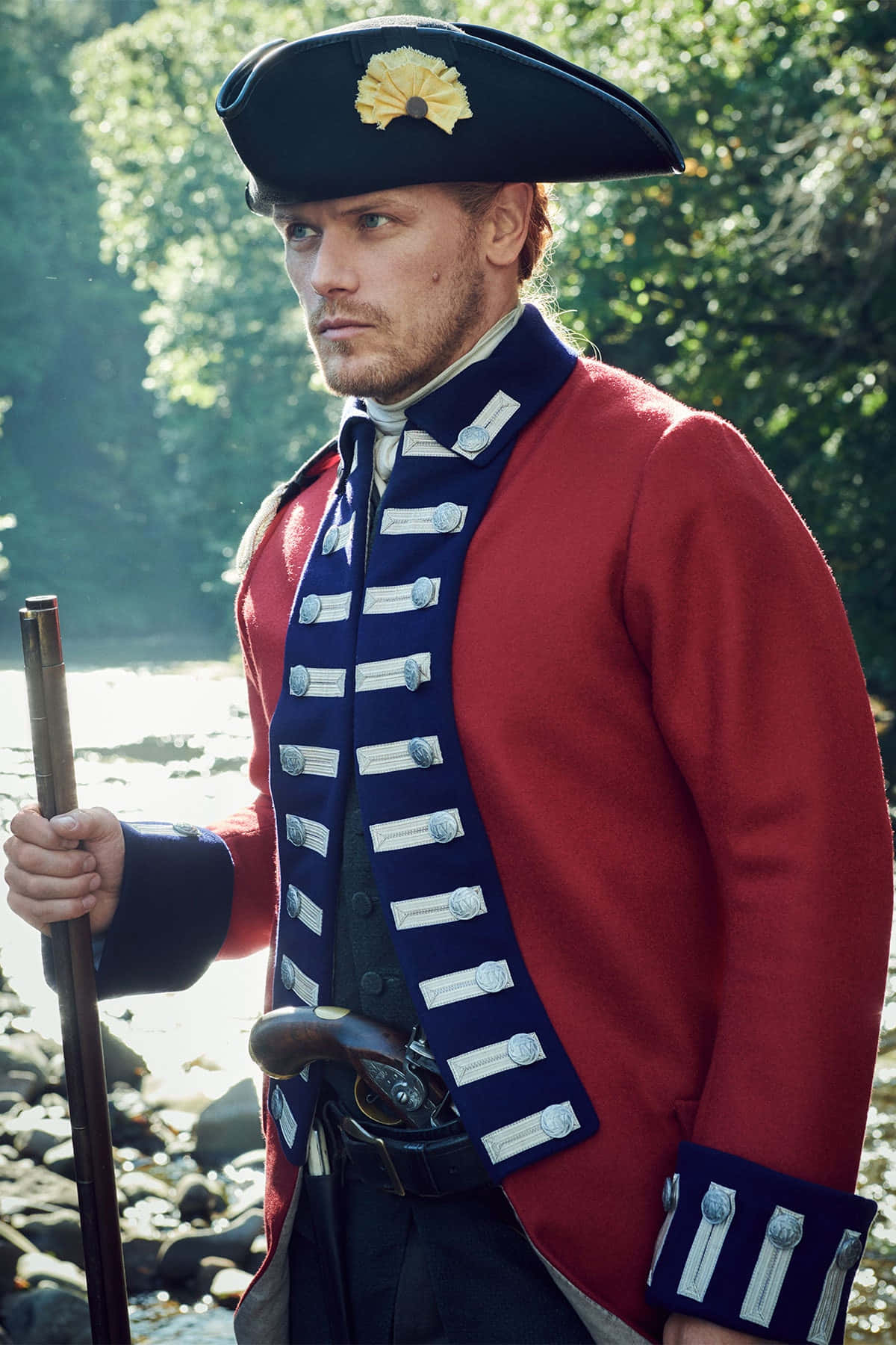 Red Coat 桌布 壁紙 — 一個身穿紅色外套和三角帽的男人站在河岸邊，手持手杖，身後有樹木。