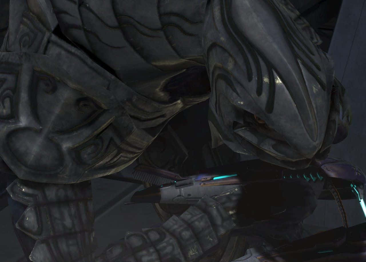 Halo Arbiter 桌布 壁紙 — 一個身穿重甲、手持藍色發光武器的外星戰士在昏暗環境中的特寫。