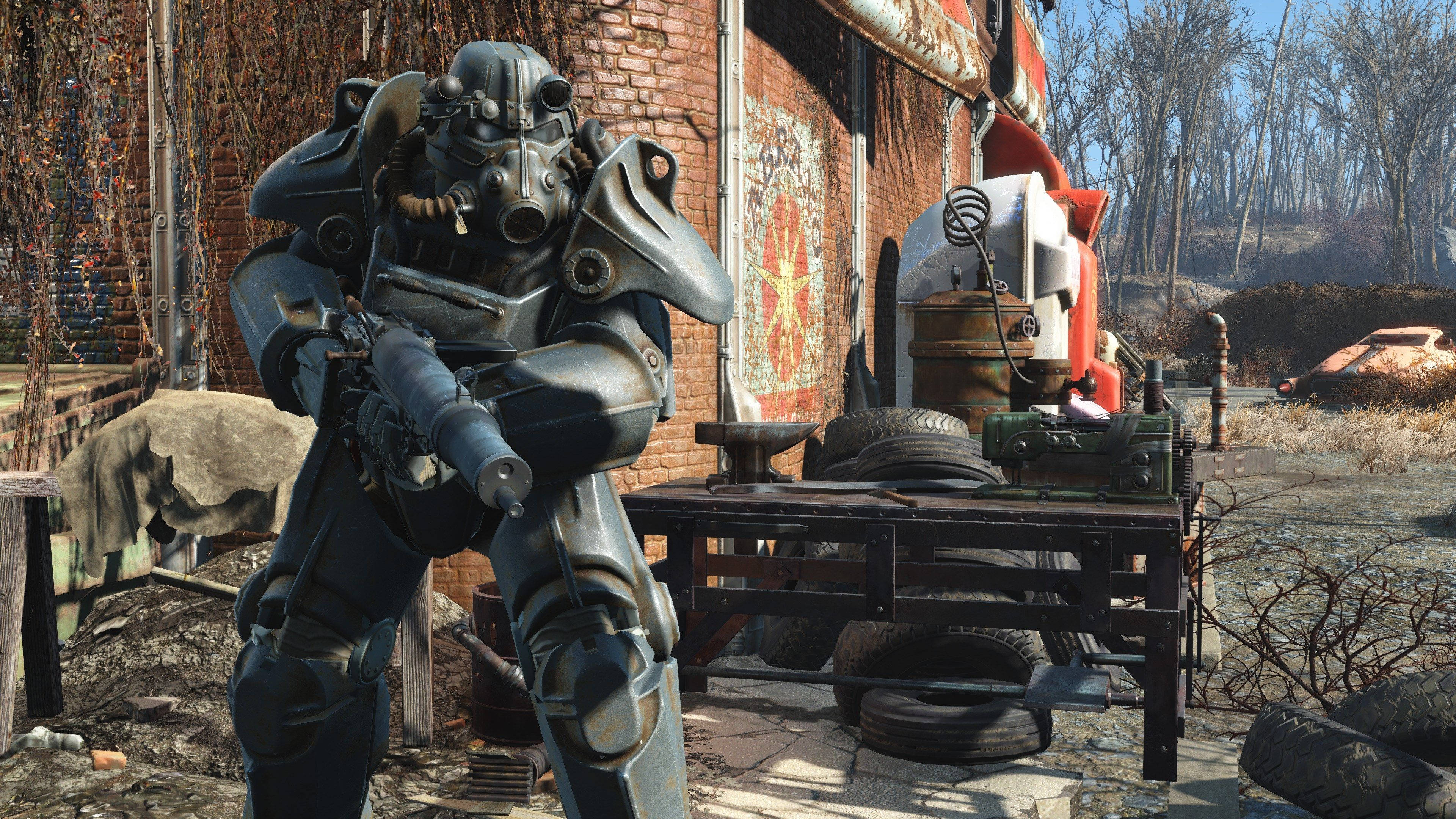 Fallout 4 桌布 壁紙 — 一個身穿重甲的廢土倖存者，在破敗的後末日廢品場中，拿著步槍在雜亂的工作檯旁站崗。