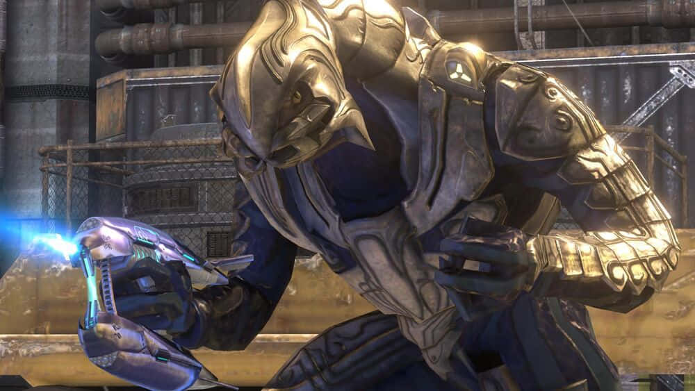 Halo Arbiter 桌布 壁紙 — 一個身穿金色和藍色盔甲的重裝外星戰士蹲在工業環境中，發射一把發光的藍色武器。