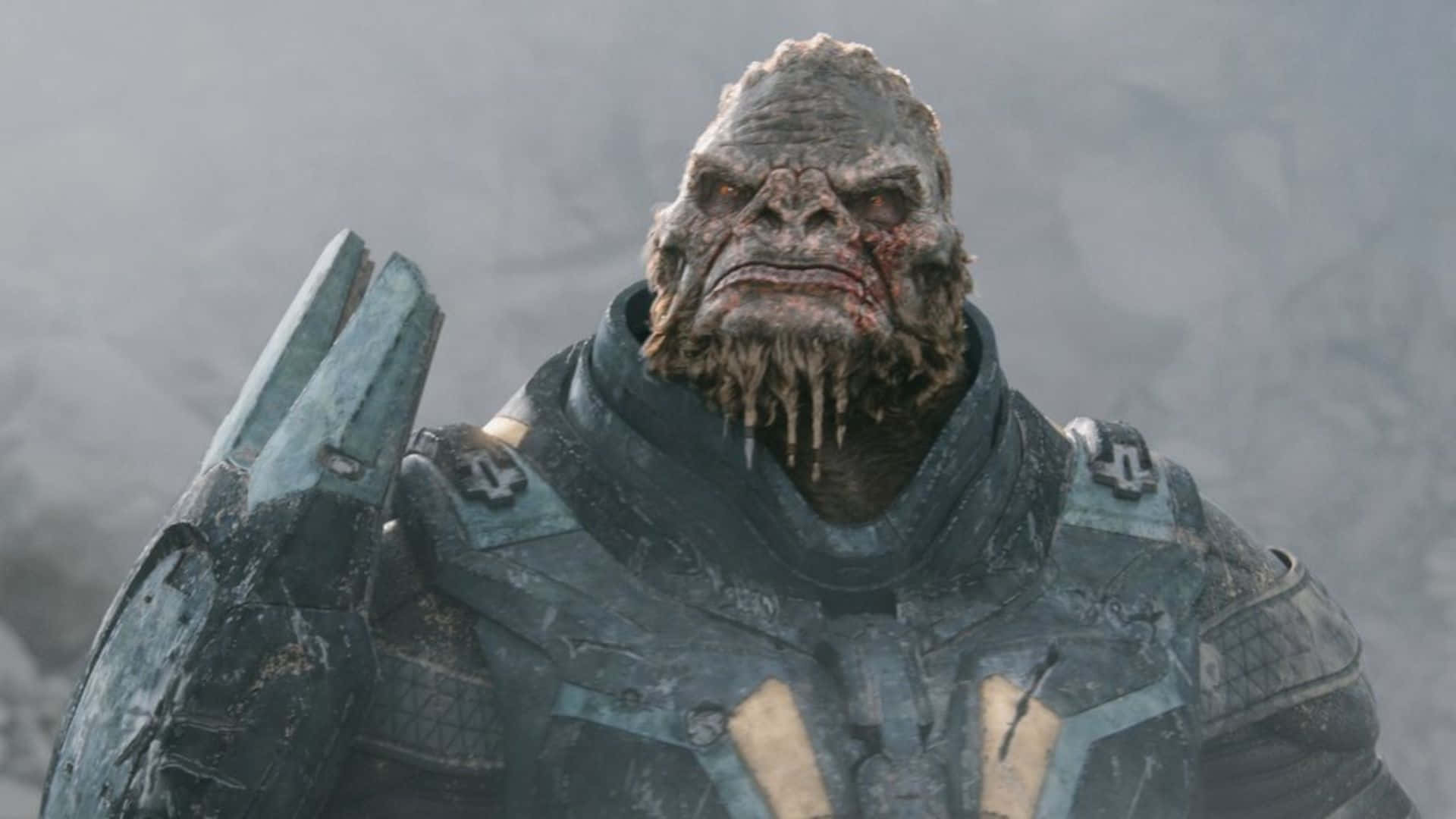 Atriox 桌布 壁紙 — 一個身穿風化盔甲、表情陰沉的外星戰士，站在迷霧般的灰色背景前。