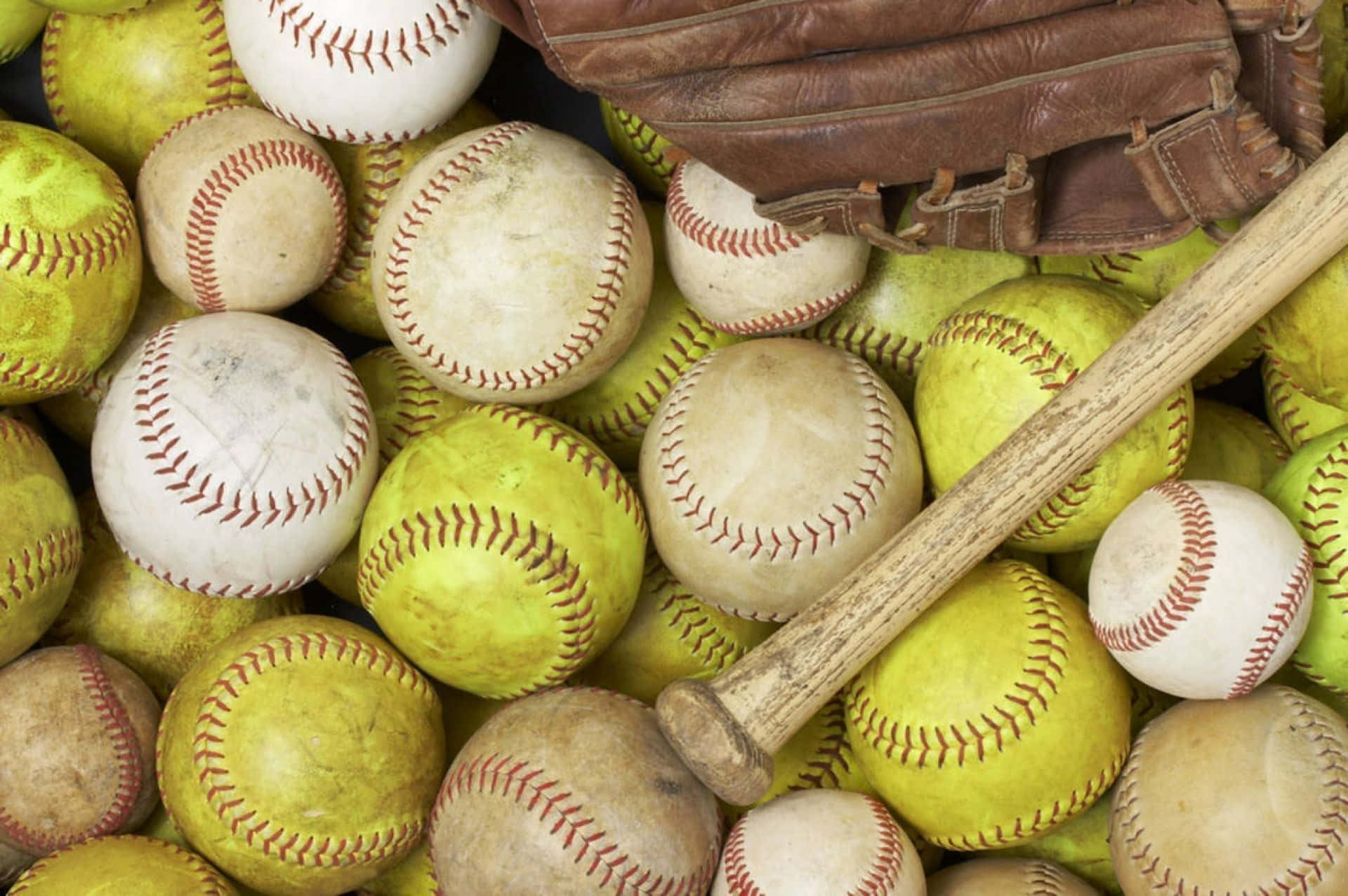 Softball 桌布 壁紙 — 一個近距離拍攝嘅風化壘球、木製球棒同皮手套堆疊埋一齊。