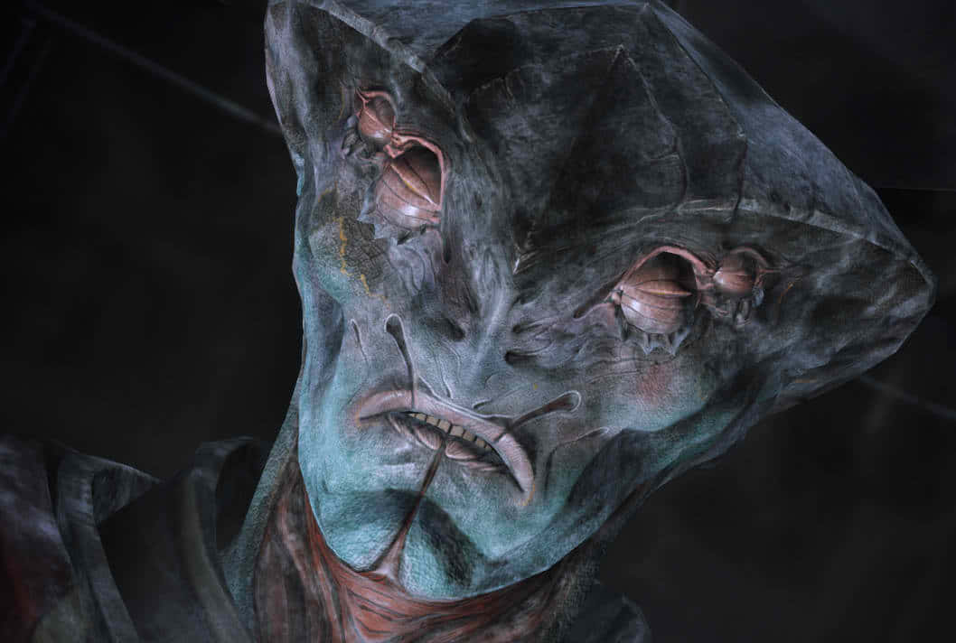 Mass Effect Javik 桌布 壁紙 — 一個近距離拍攝的怪異外星生物，擁有紋理豐富的藍綠色皮膚和凸出的眼睛，背景陰暗。