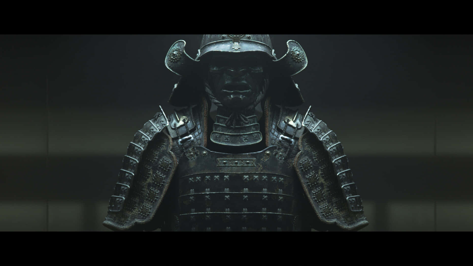 Samurai Armor 桌布 壁紙 — 一個近距離特寫，展示一位身穿精細暗色盔甲、頭盔遮蓋臉部的武士戰士，背景昏暗。