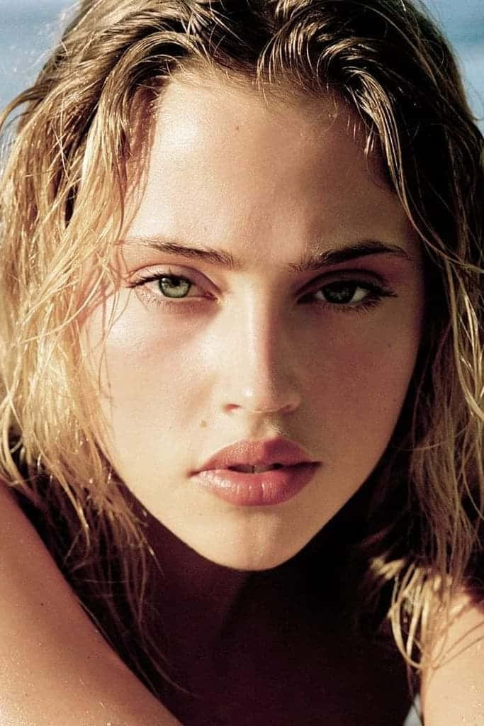 Estella Warren 桌布 壁紙 — 一個近距離肖像，一位擁有濕透金髮和綠色眼睛的女性在明亮陽光下直視鏡頭。