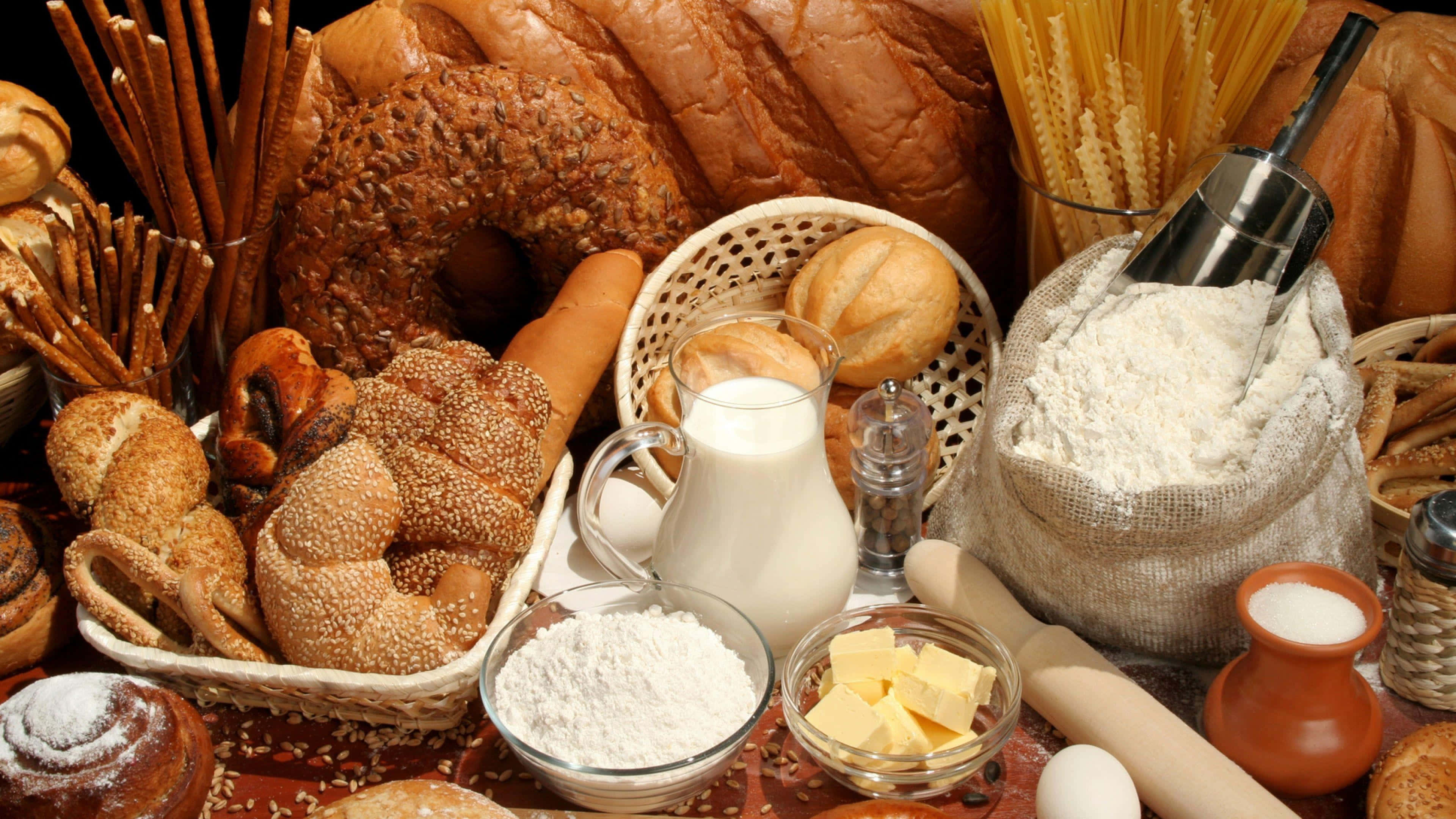 Bakery 桌布 壁紙 — 一個鄉村風格的靜物擺設，包括新鮮麵包、糕點、麵粉、牛奶、牛油和雞蛋，誘人地排列著準備烘焙。