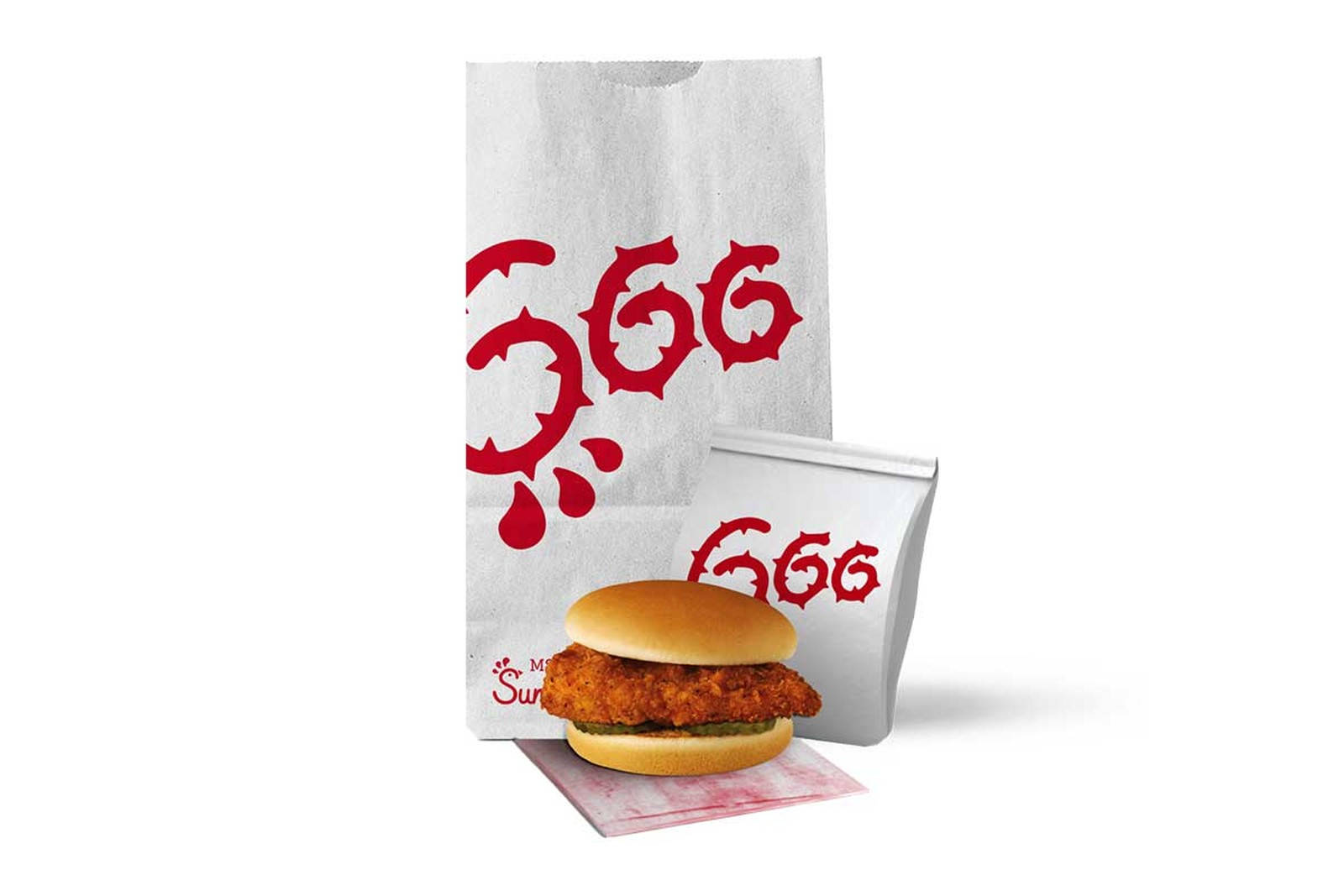 MSCHF x Chick Fil A 壁紙 — 一個酥脆的炸雞三文治放在有品牌的餐巾上，旁邊有兩個白色紙袋，上面有粗體紅色的「GOG」標誌。