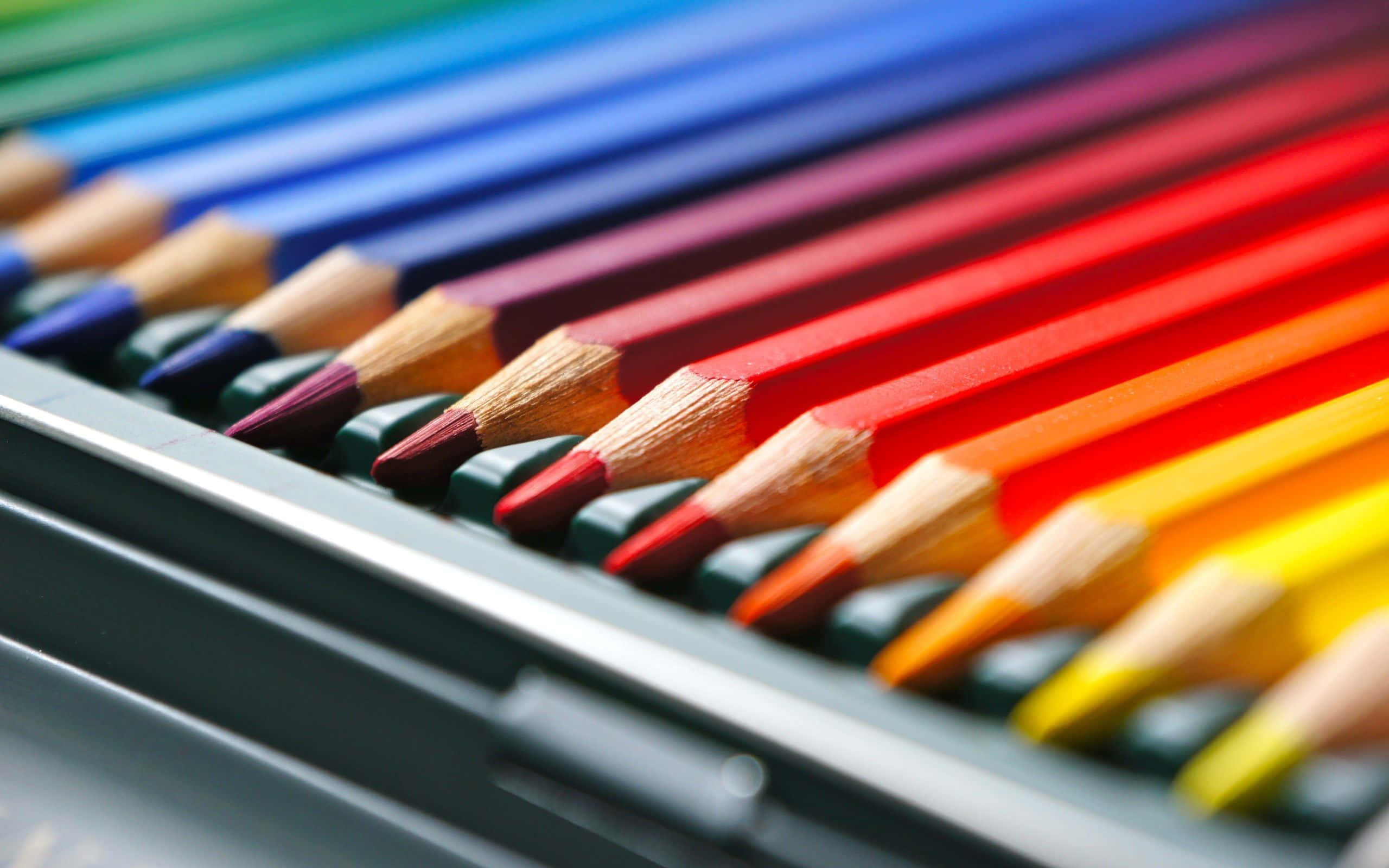 pencil 桌布 壁紙 — 一個金屬盒內，削尖的彩色鉛筆以彩虹漸變排列的鮮明特寫。