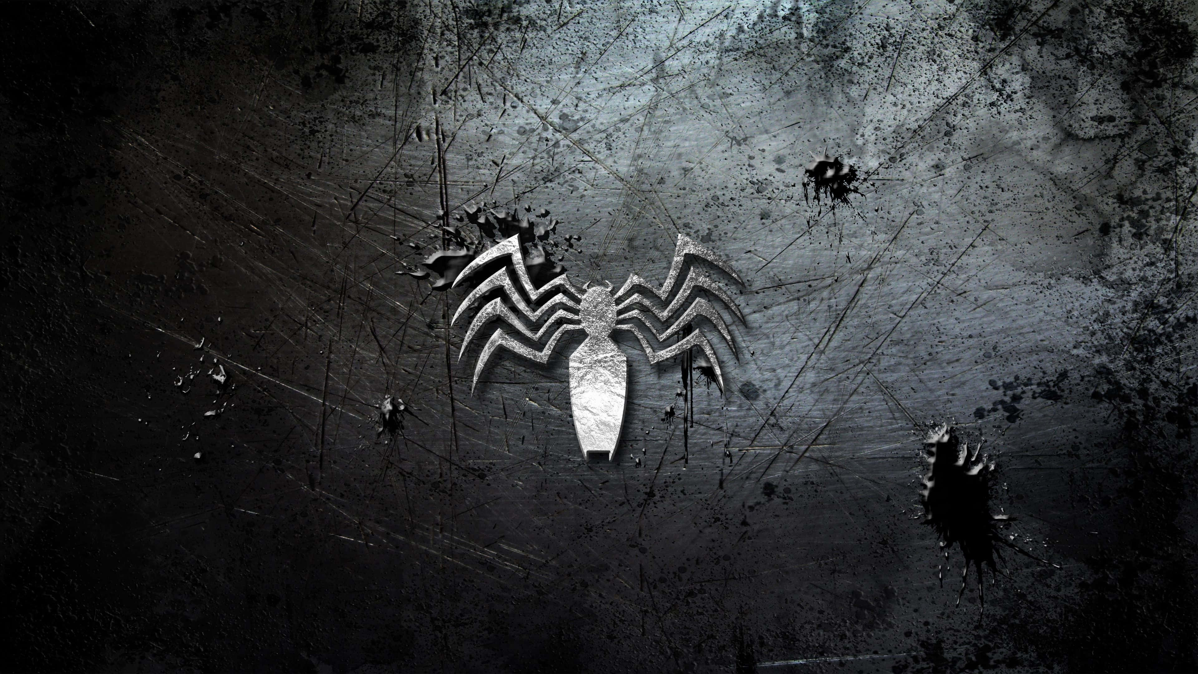 Venom Logo 桌布 壁紙 — 一個金屬蜘蛛標誌喺一個粗糙嘅黑色牆上閃耀，牆上濺滿黑色油漆同刮痕。