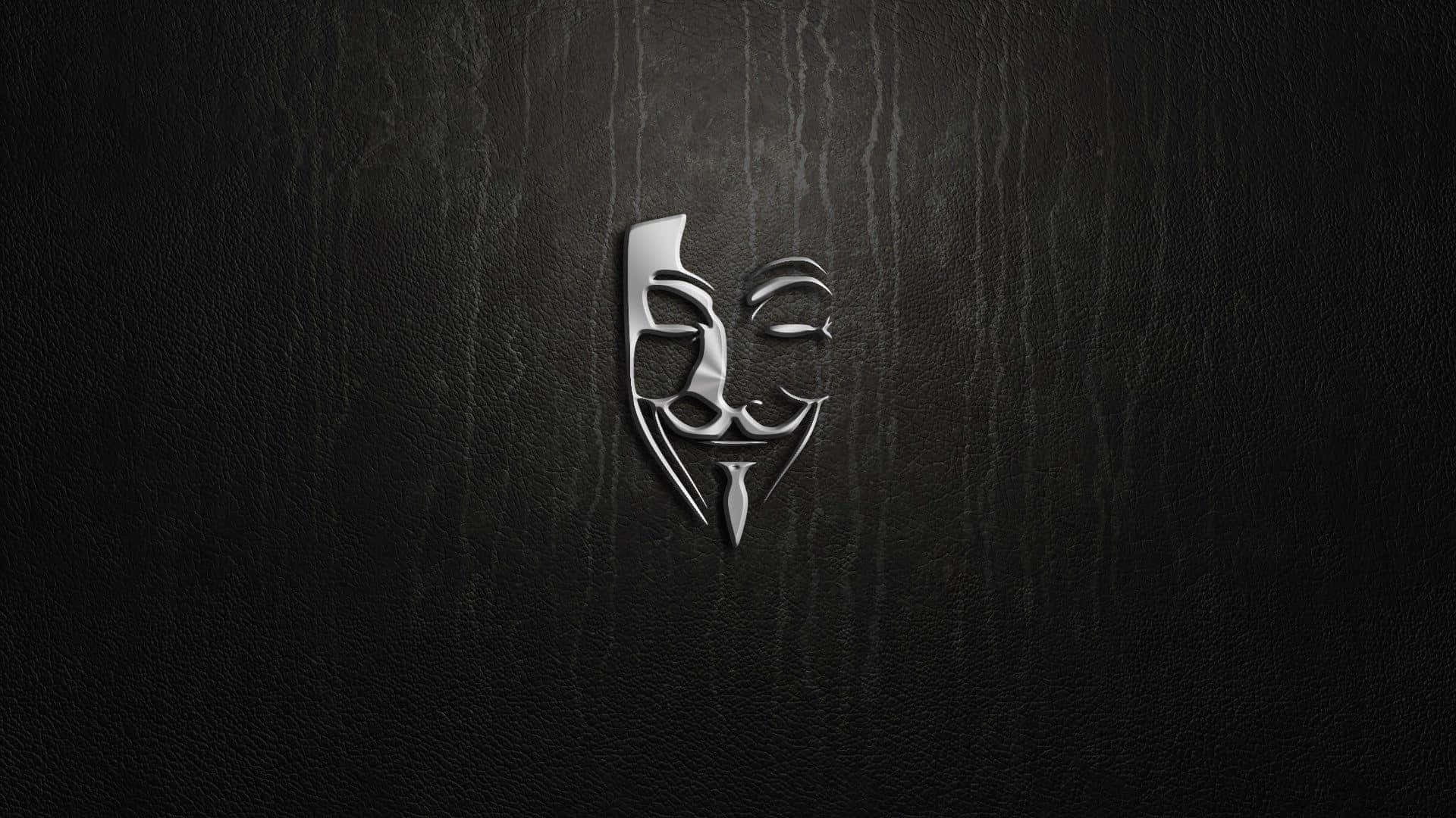 Anonymous 桌布 壁紙 — 一個金屬質感的蓋伊·福克斯面具在帶有微妙垂直條紋的深色紋理皮革背景上閃耀。