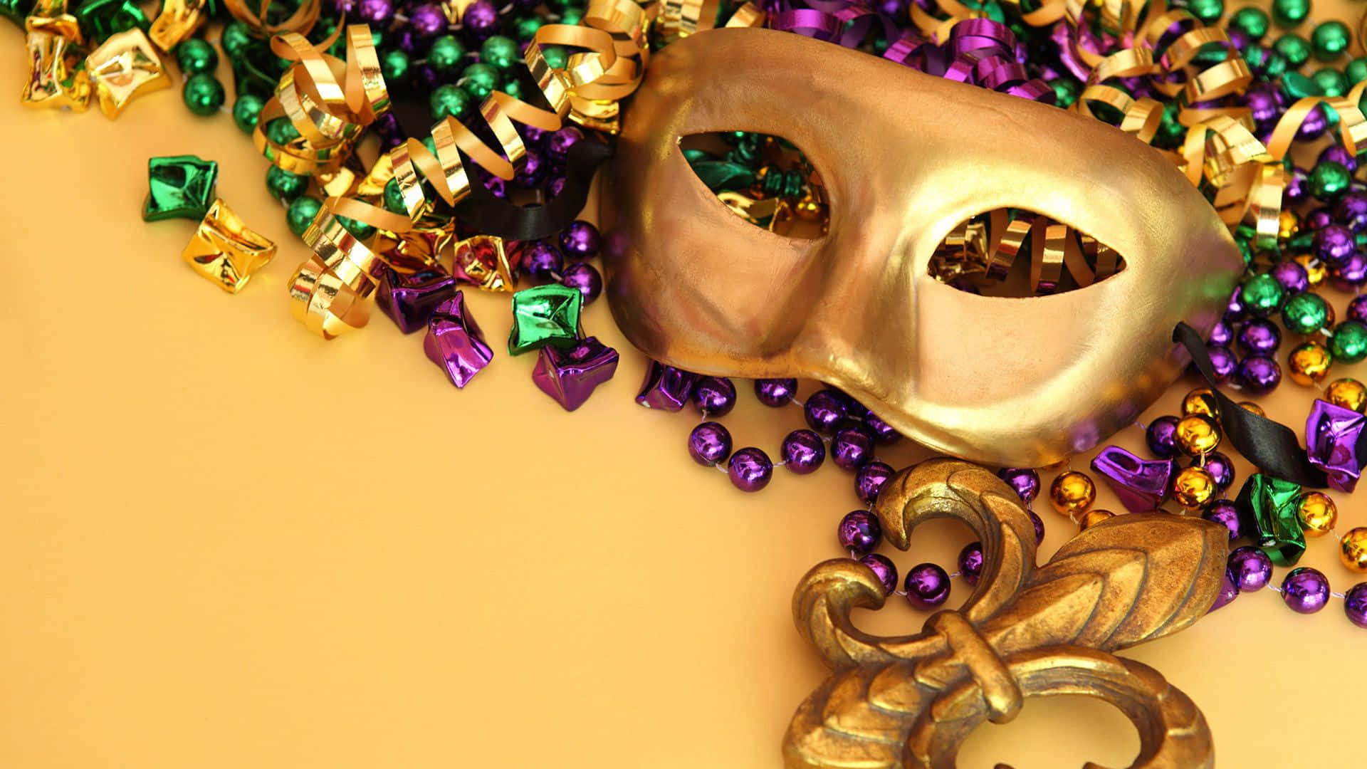 Accessory 桌布 壁紙 — 一個金色狂歡節面具放在充滿活力的紫色、綠色和金色珠子以及節日五彩紙屑中，背景是溫暖的黃色。