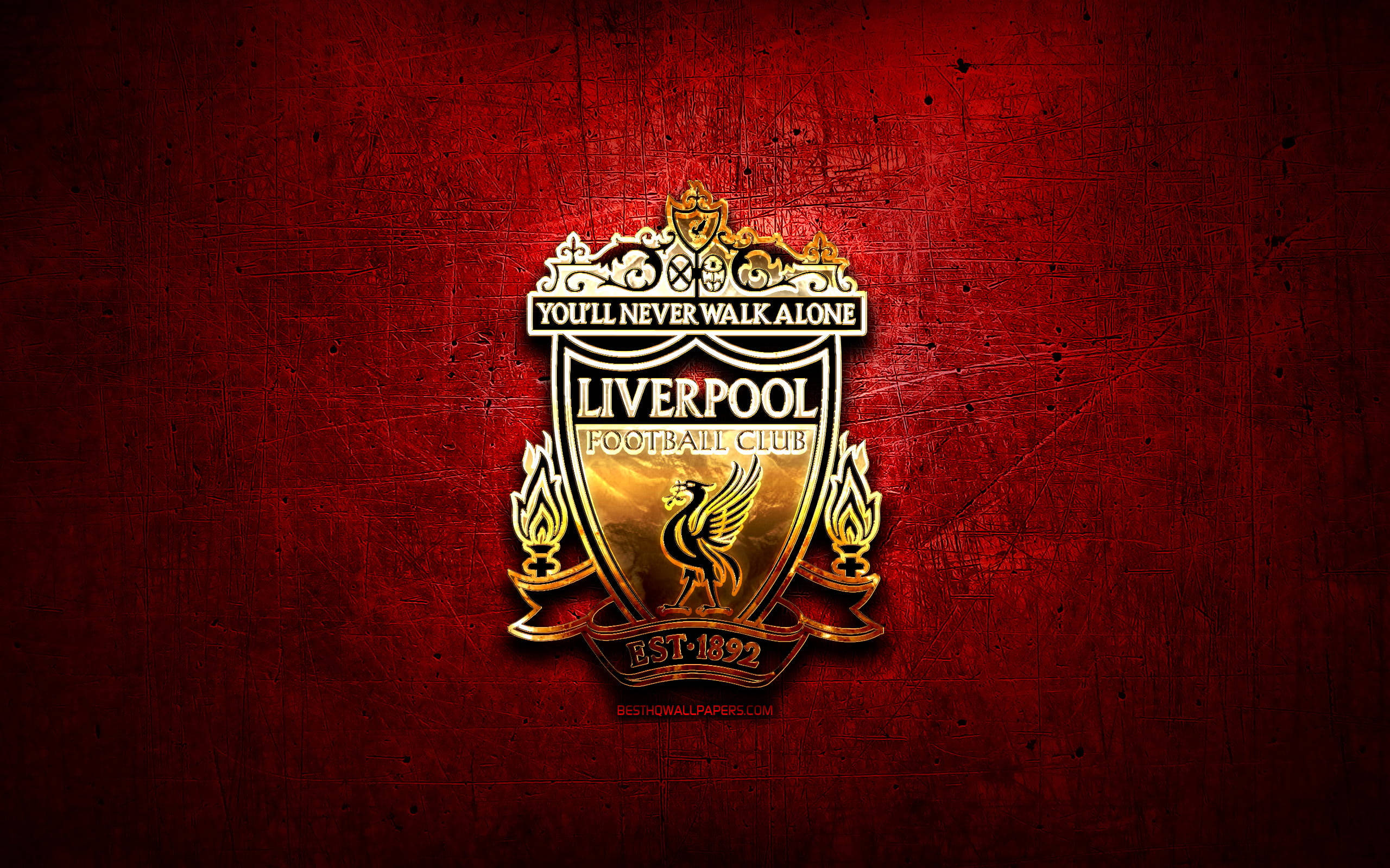 Liverpool Fc 桌布 壁紙 — 一個金色的利物浦足球會徽章在帶有刮痕和磨損的紋理深紅色背景上閃耀。