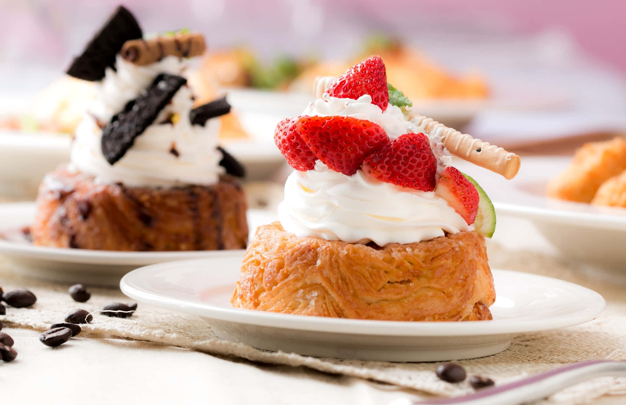 Cute Dessert 桌布 壁紙 — 一個金色糕點的近距離特寫，上面有鮮奶油、新鮮草莓和威化棒，放在白色碟子上，附近散落著咖啡豆。