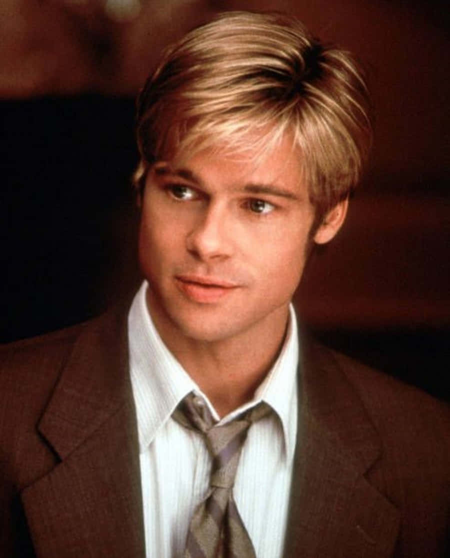 Brad Pitt 桌布 壁紙 — 一個金髮男子穿著棕色西裝和圖案領帶，在深色背景下的特寫肖像。