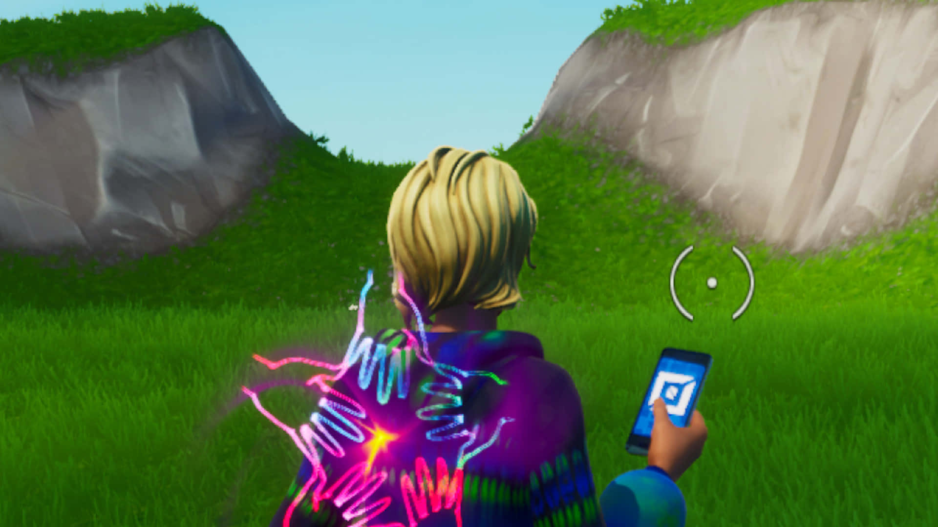 Creative Mode 桌布 壁紙 — 一個金髮角色穿著彩色連帽衫，站在岩石懸崖之間的草地山谷中，手持發光手機，背後有霓虹能量效果旋轉。