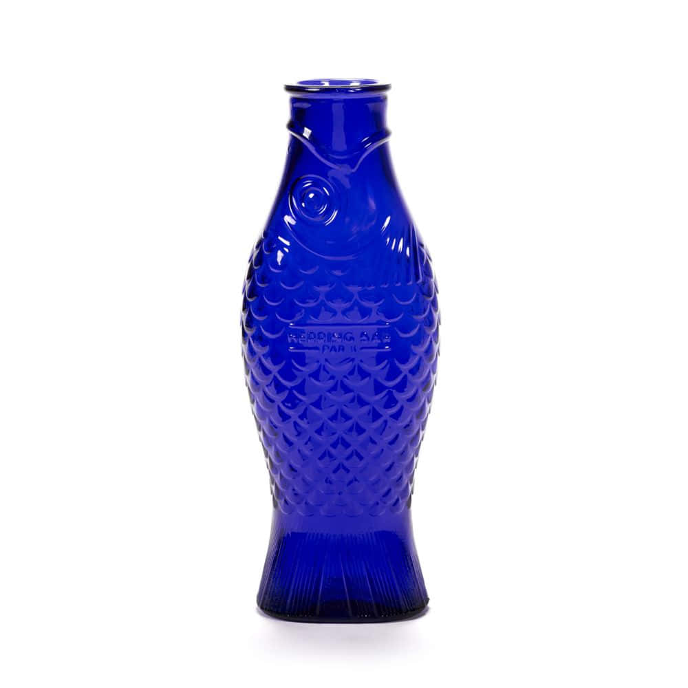 Cobalt Blue 桌布 壁紙 — 一個鈷藍色玻璃花瓶，形狀像魚，帶有紋理鱗片和浮雕細節，矗立在純白色背景前。