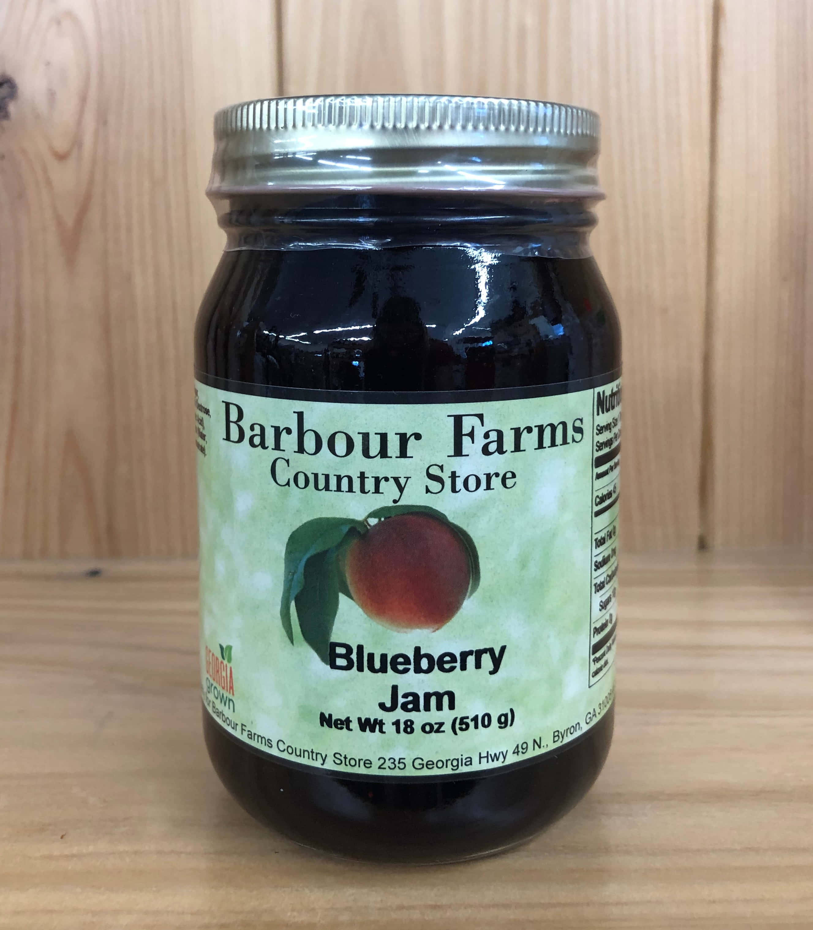 Blueberry Jam 桌布 壁紙 — 一個銀蓋藍莓果醬玻璃罐放在木質表面上，背景是木鑲板。