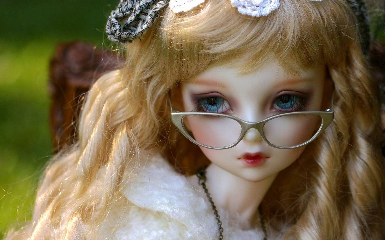 Doll 桌布 壁紙 — 一個長金髮戴眼鏡的公仔喺柔和自然光下坐喺戶外嘅特寫。